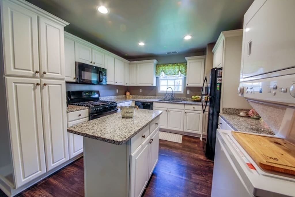 Gather around the kitchen island — full appliances, plenty of prep space, and room for everyone.