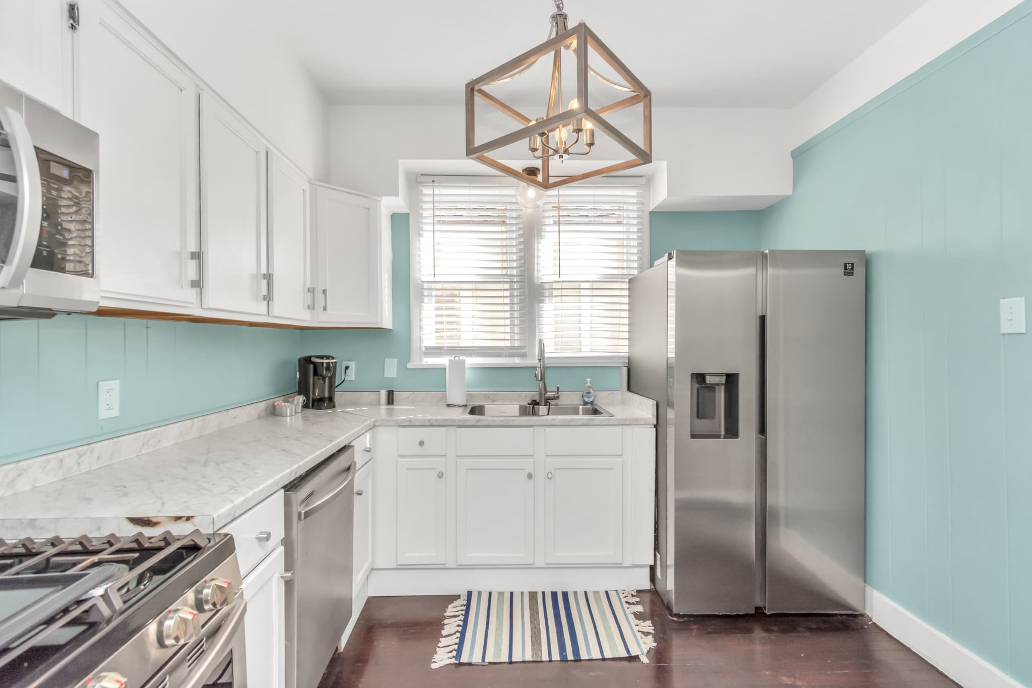Full kitchen with full refrigerator, with oven, microwave, and stove with ample cooktop area and cabinets and double sinks.