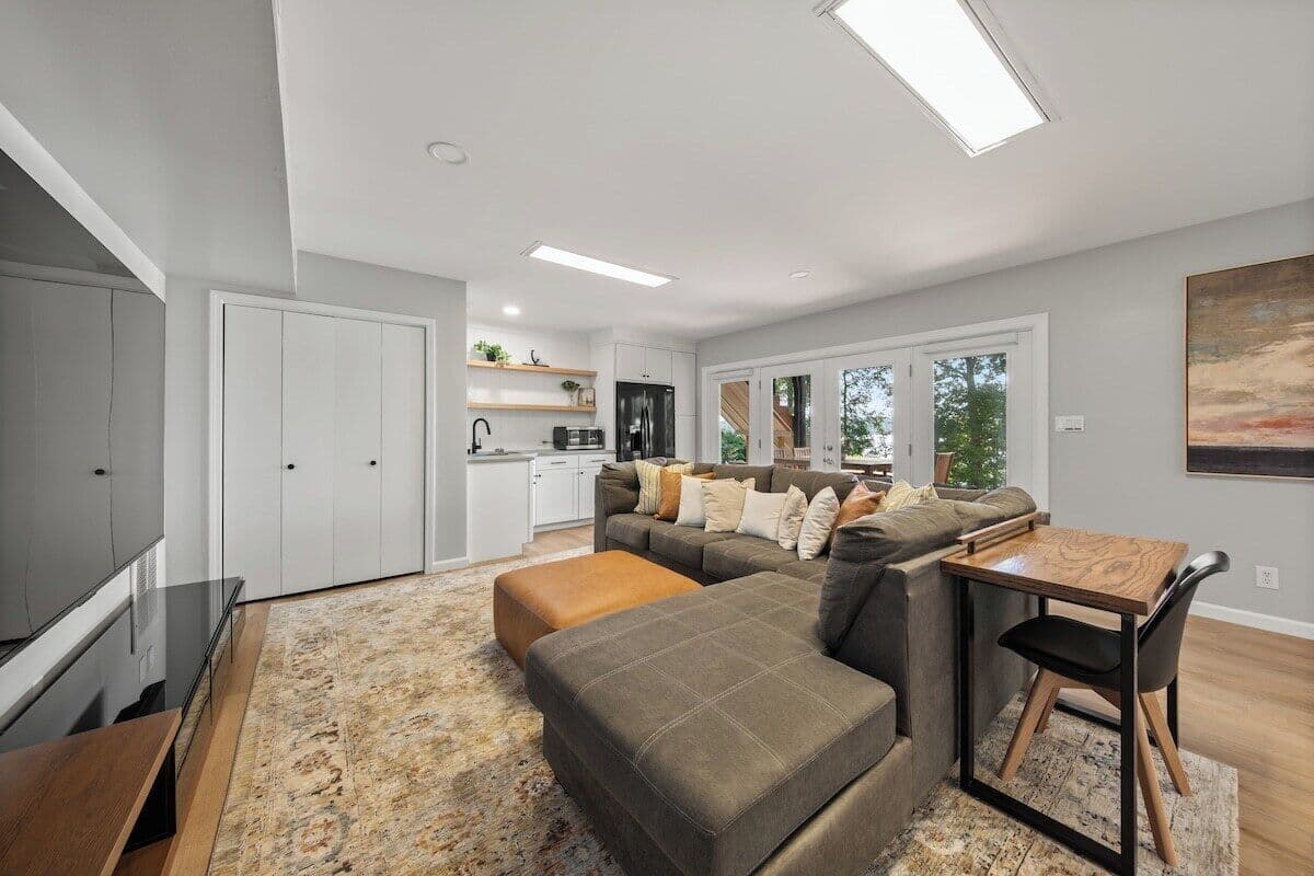 85" TV with couch and wrap-around table and chairs with total seating for 10+.