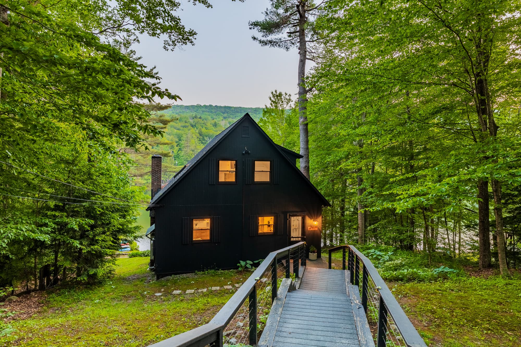 Welcoming front deck framed by tall trees