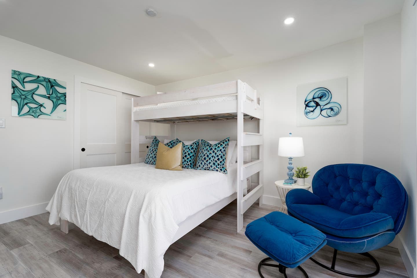 Second bedroom with a twin bunk, queen bed, and a cozy lounging chair