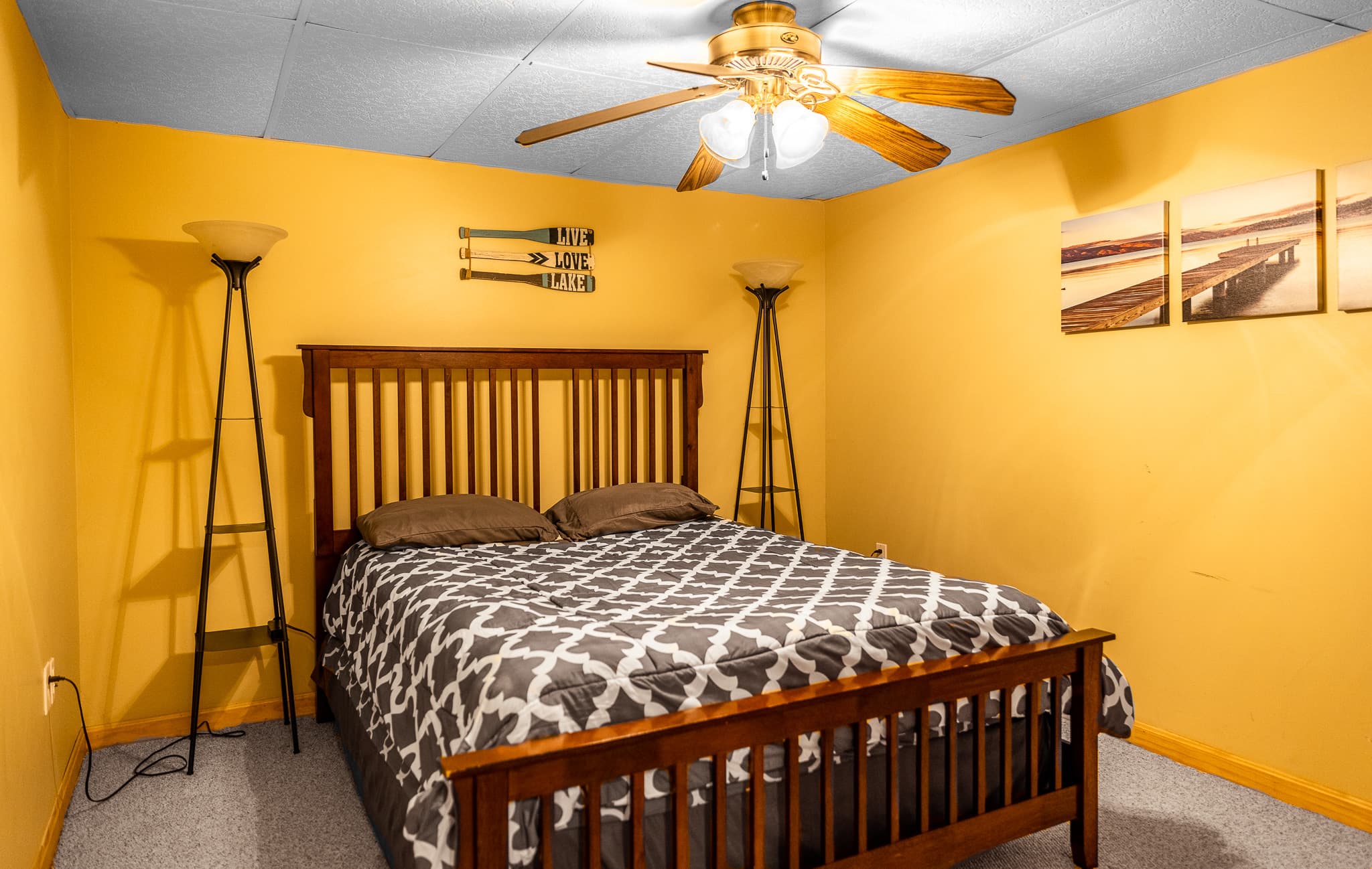 Downstairs bedroom with queen bed, closet, ceiling fan.