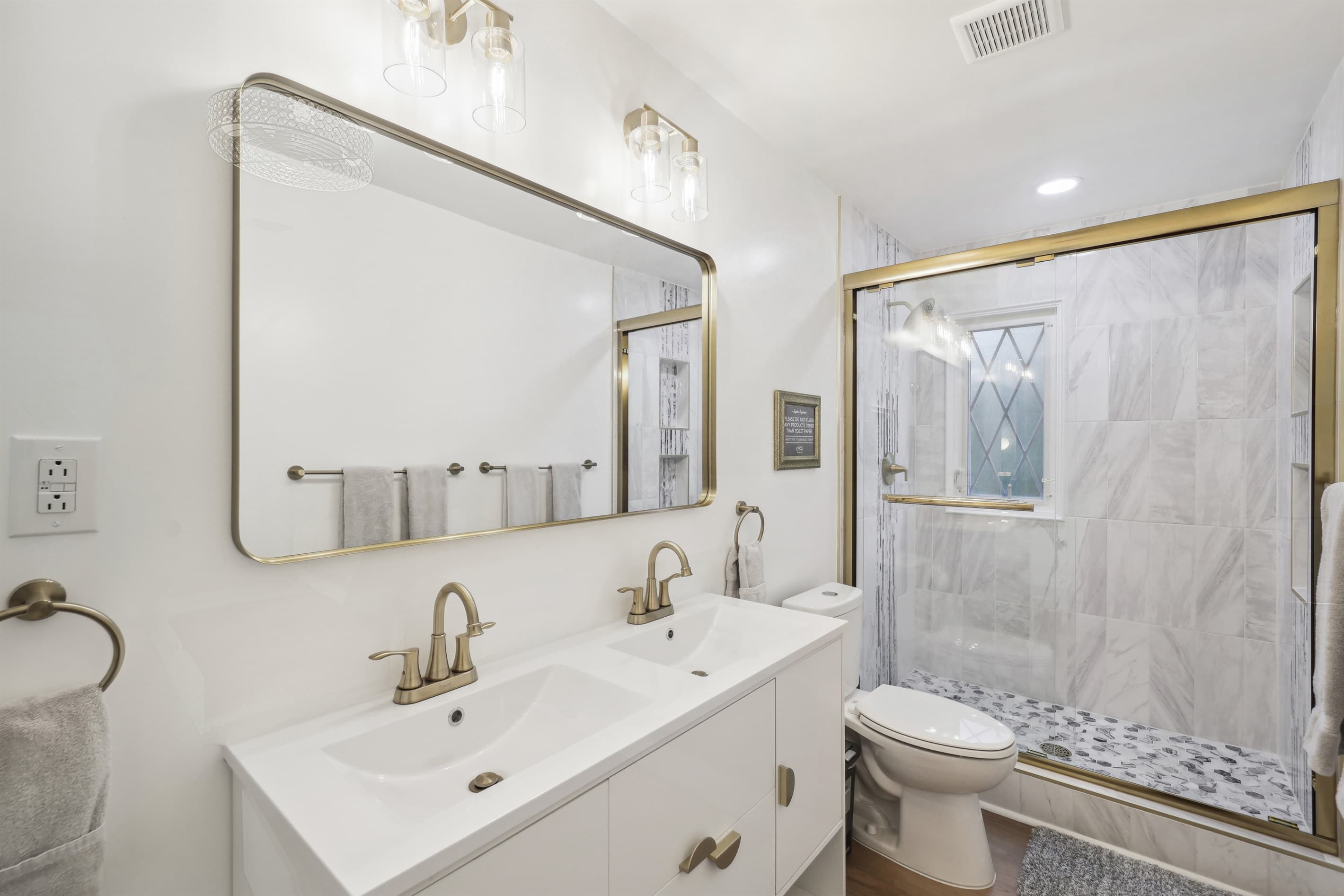 This upstairs bathroom has a marble walk-in shower and double vanity.