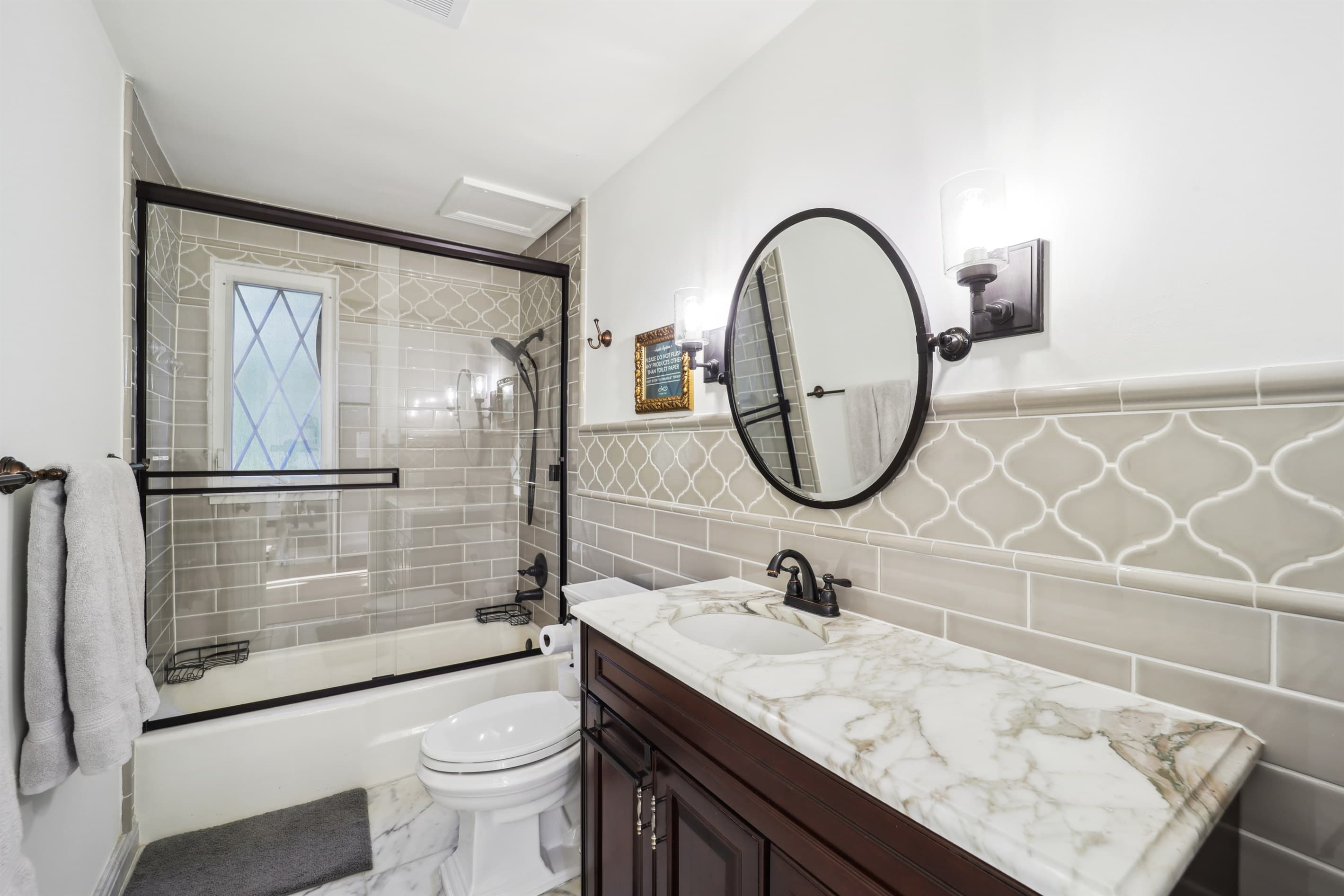 This bathroom is on the main level and is equipped with a tub and has a beautiful marble vanity and marble floors.