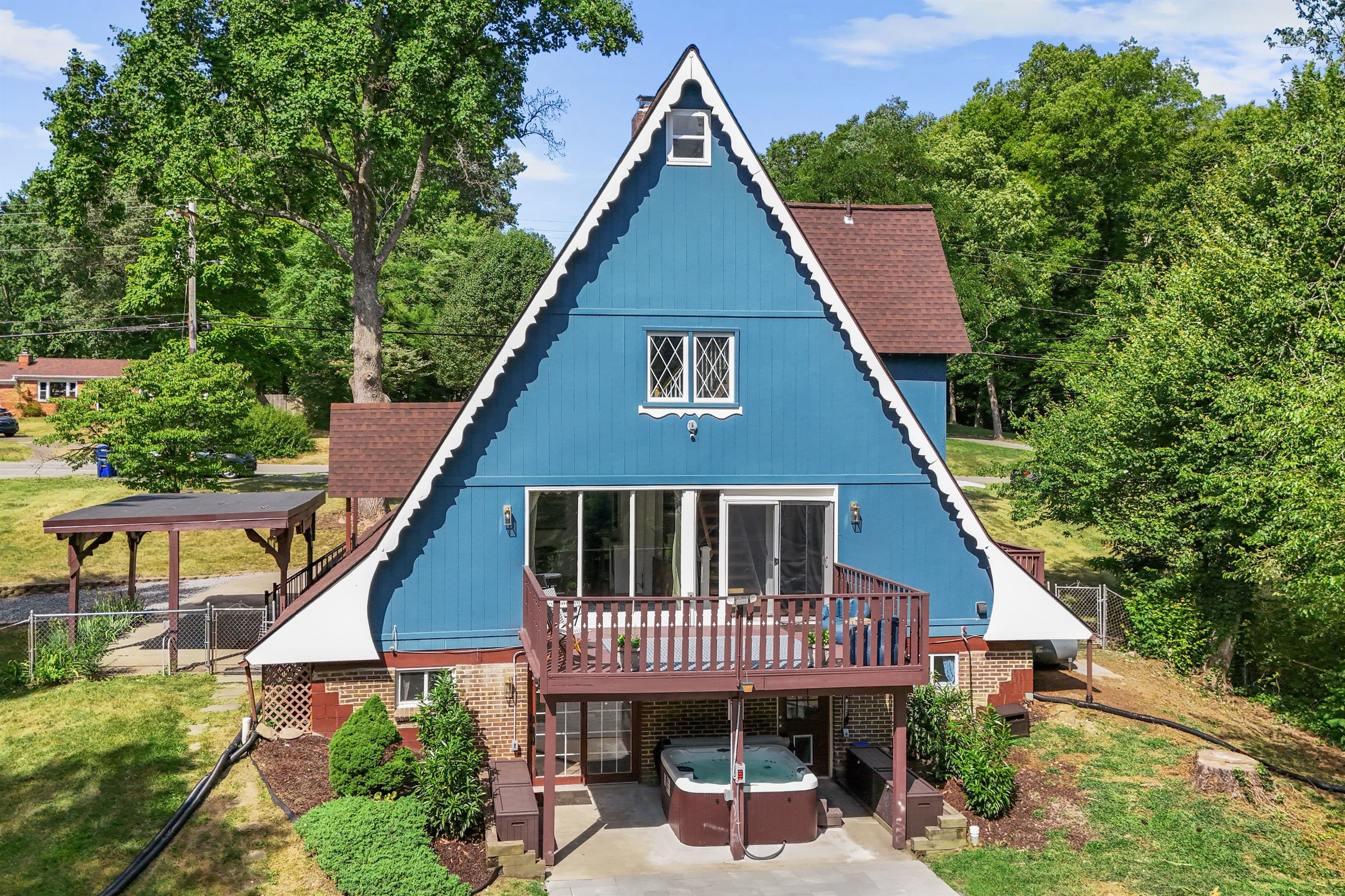 The back of the house is equipped with a deck and hot tub under the deck area.
