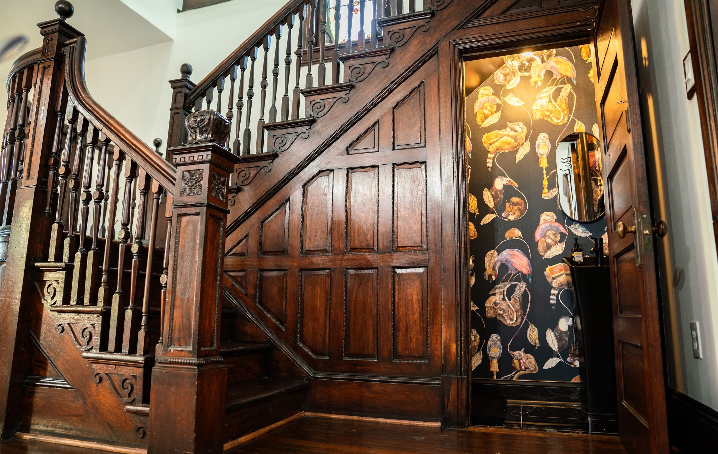 There is a moody half bathroom under the antique staircase by the dining room