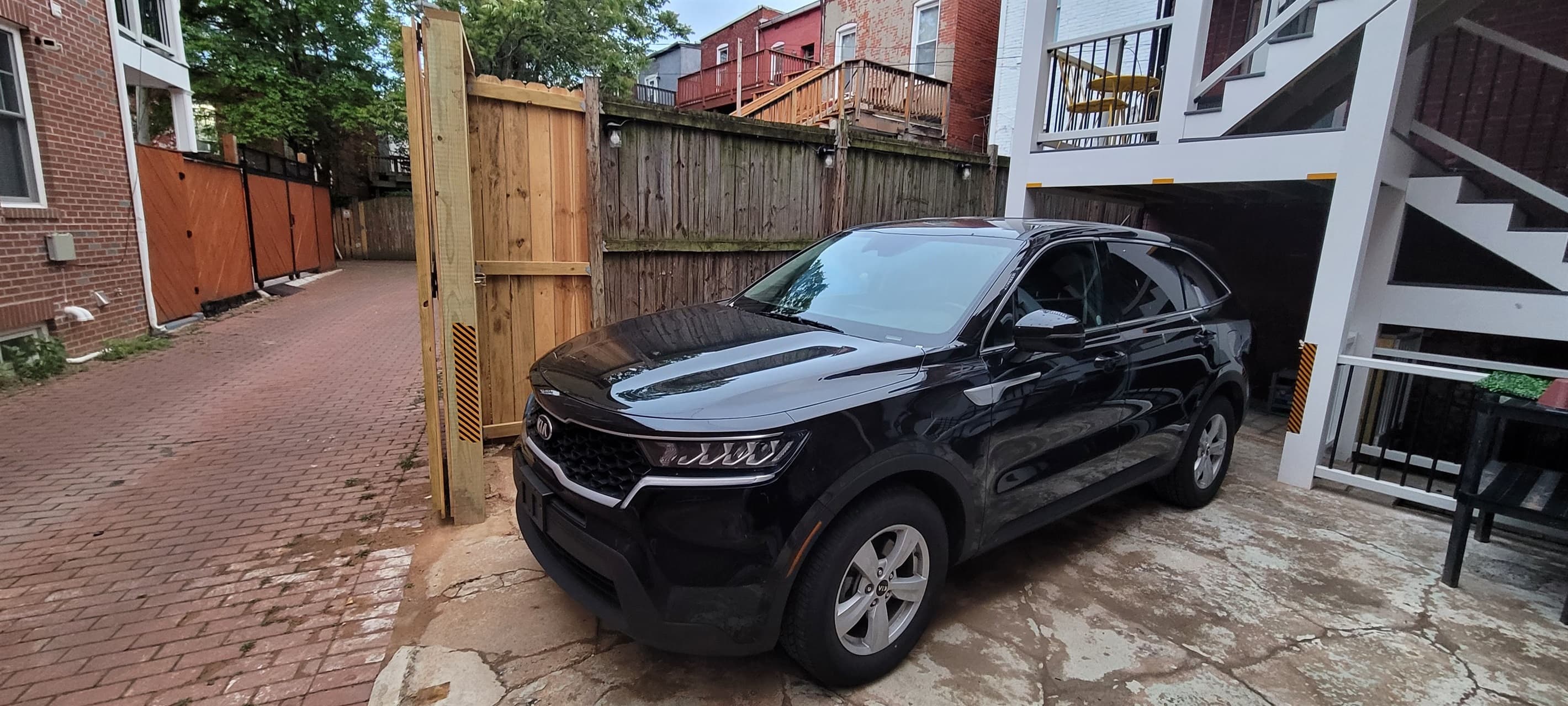 The parking pad in the back can typically accommodate up to a mid-size SUV / Minivan (pictured is a Kia Sorento). Part of the parking pad is underneath the deck posts, which can accommodate a vehicle that is 83 inches wide and 79 inches high.