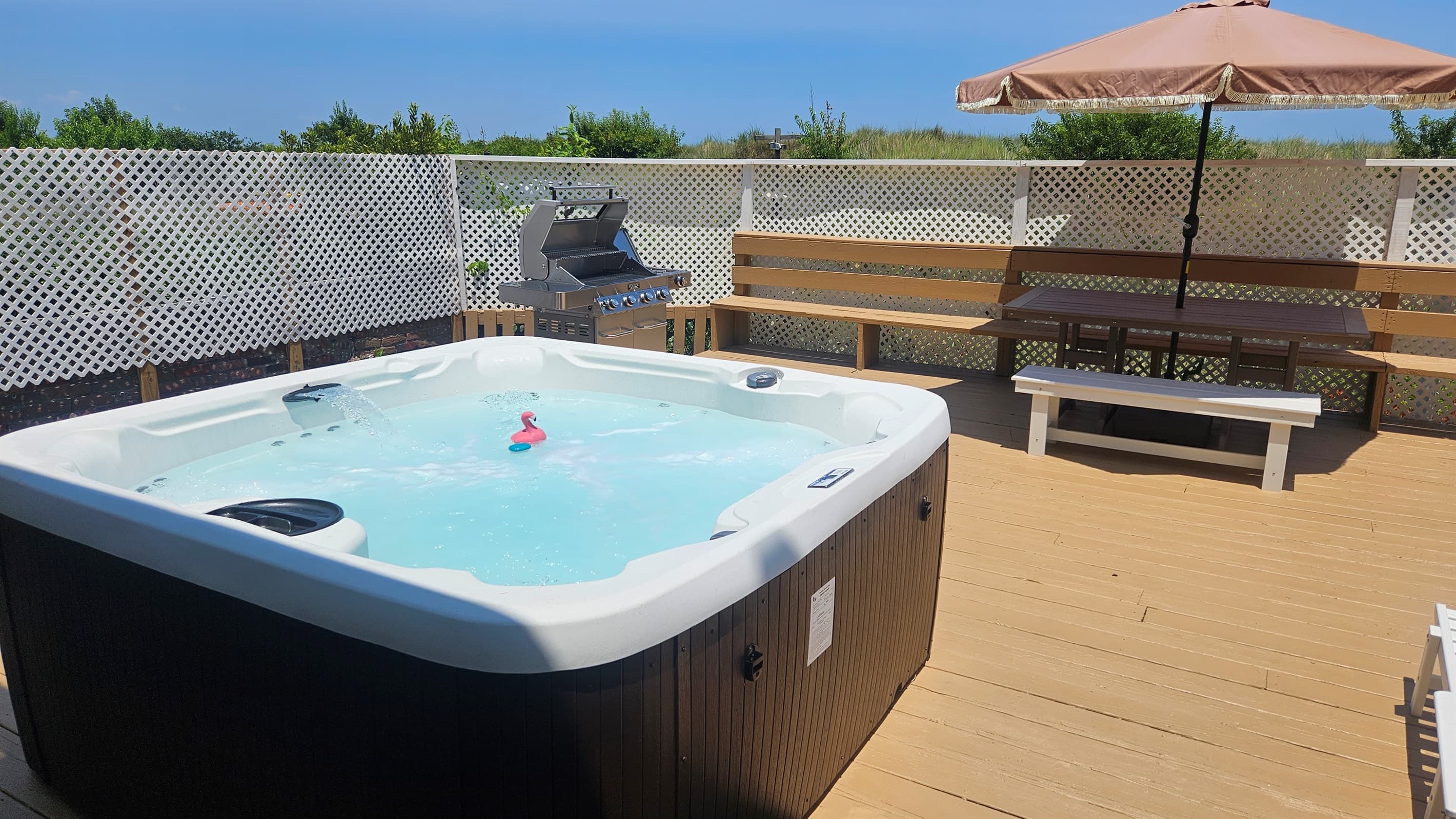 Backyard has the 7-person Hot Tub, BBQ Grill, and table with umbrella for dining outdoors