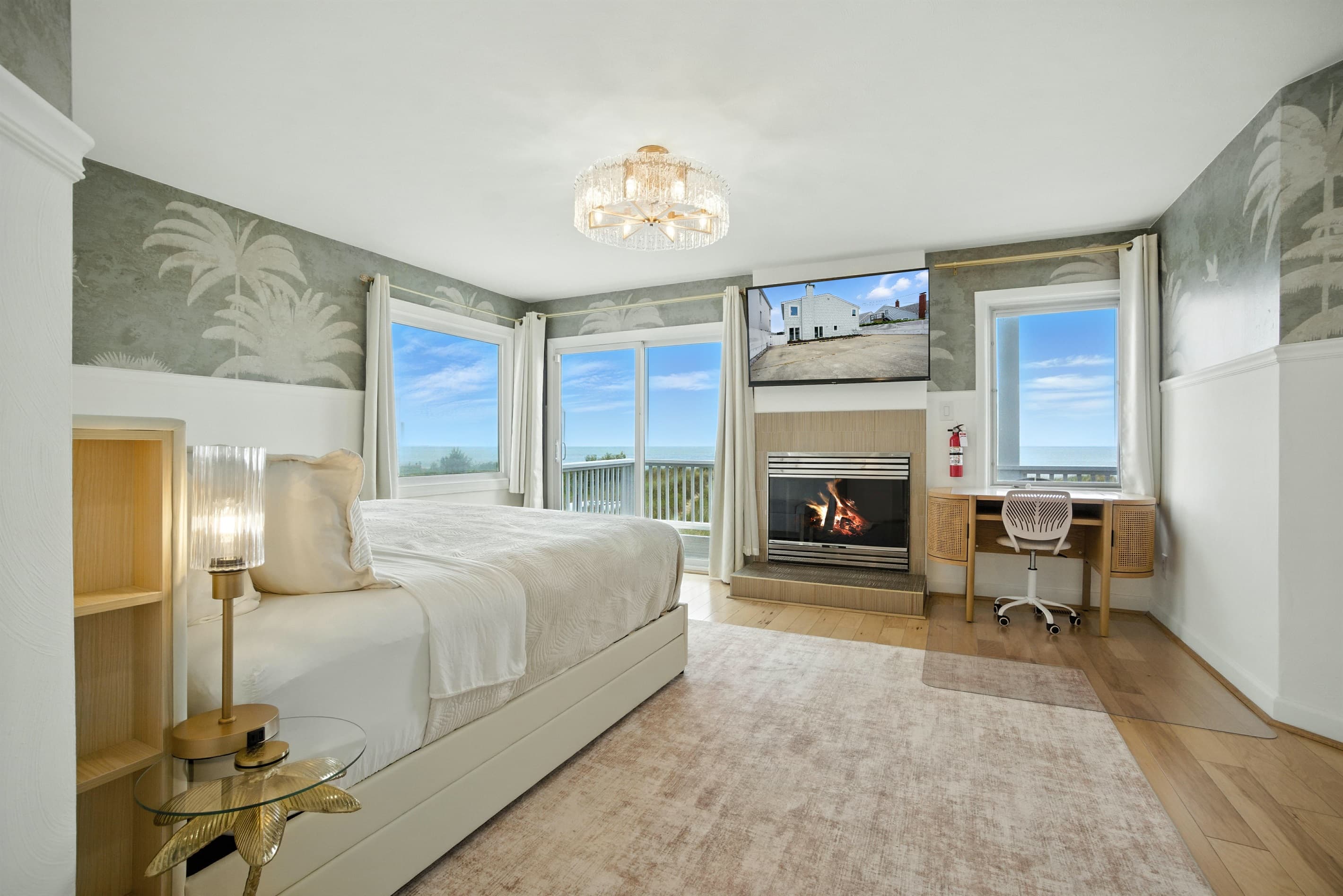 Primary Bedroom in Unit A has ocean views, a King bed, a Large En-Suite Bathroom, a gas fireplace, desk and large walk-in closet