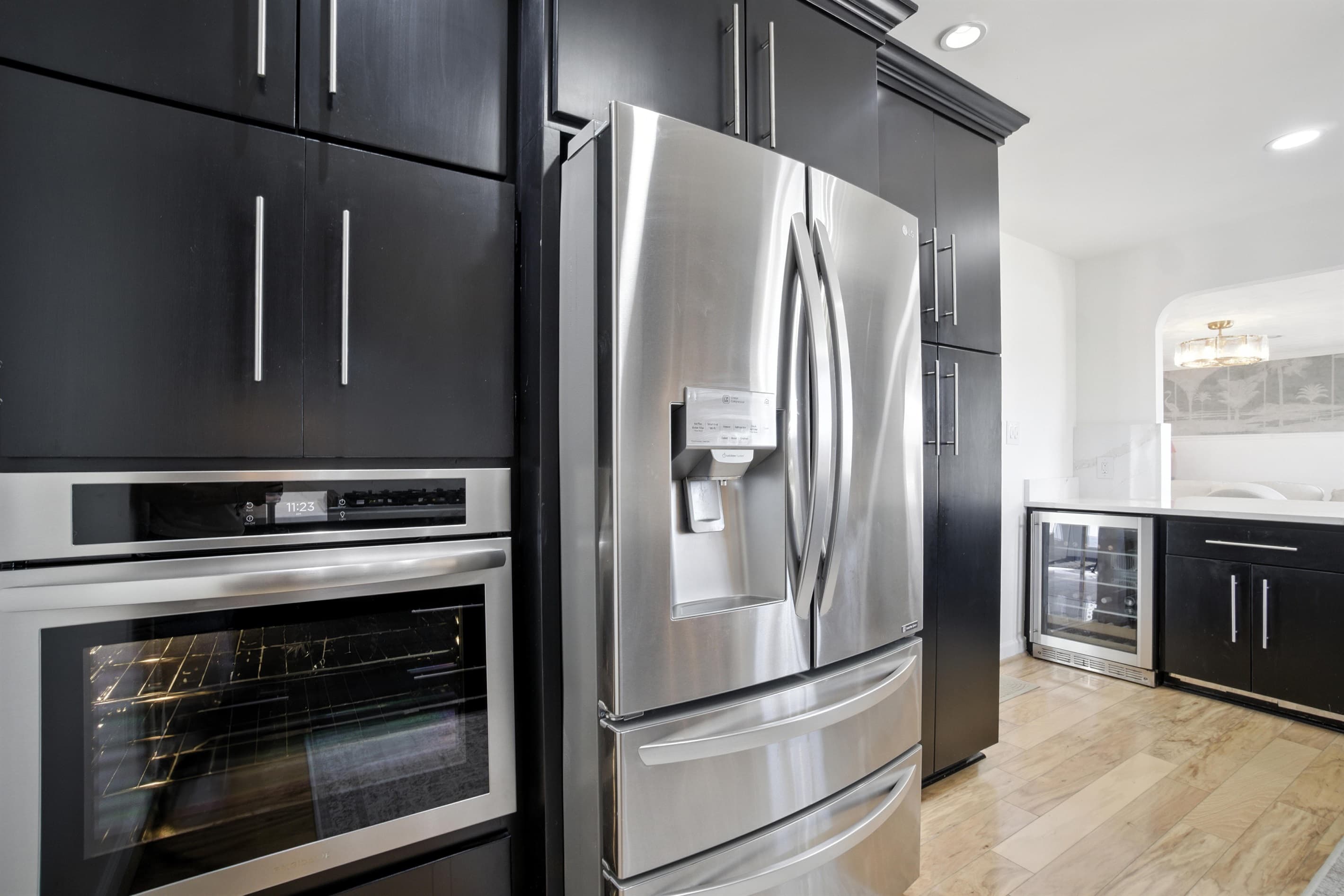 Wall Oven is next to the fridge, with a Microwave in the cabinet above the wall oven
