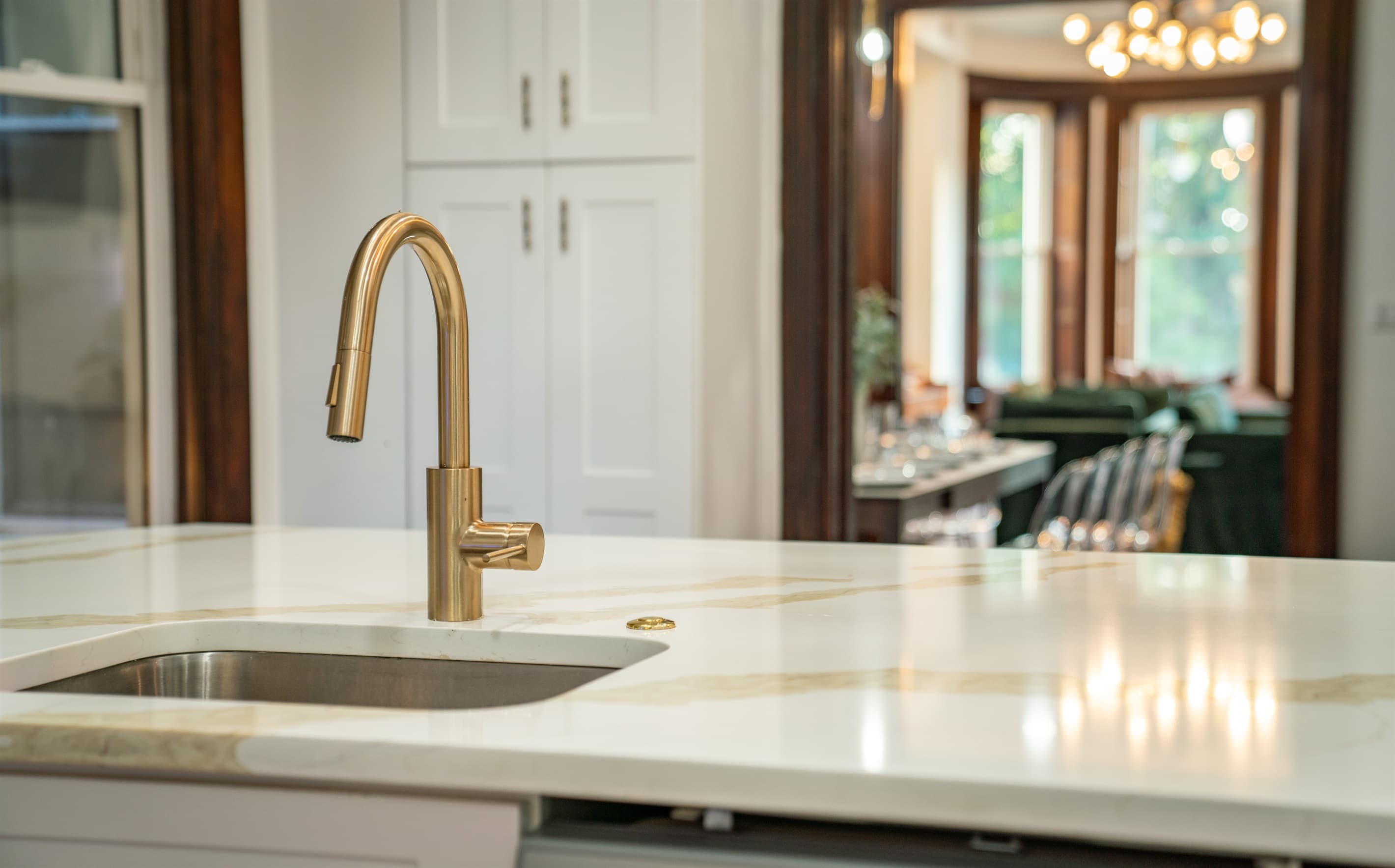 The kitchen has quartz countertops and backsplash, complemented with gold accent fixtures