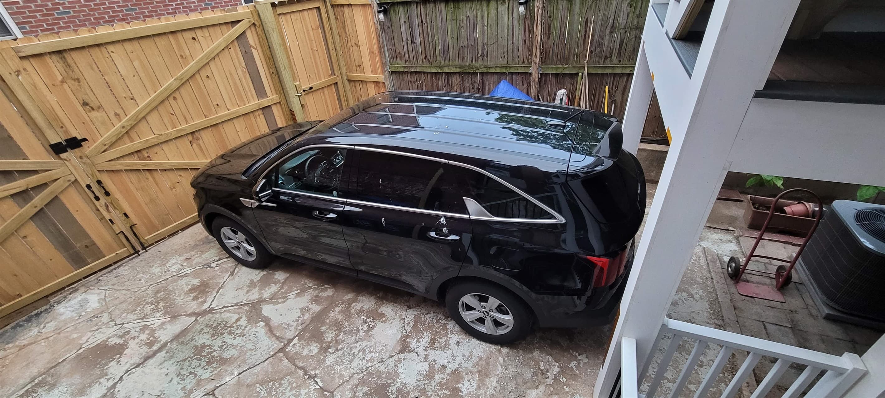 The parking pad in the back can typically accommodate up to a mid-size SUV / Minivan (pictured is a Kia Sorento). Part of the parking pad is underneath the deck posts, which can accommodate a vehicle that is 83 inches wide and 79 inches high.