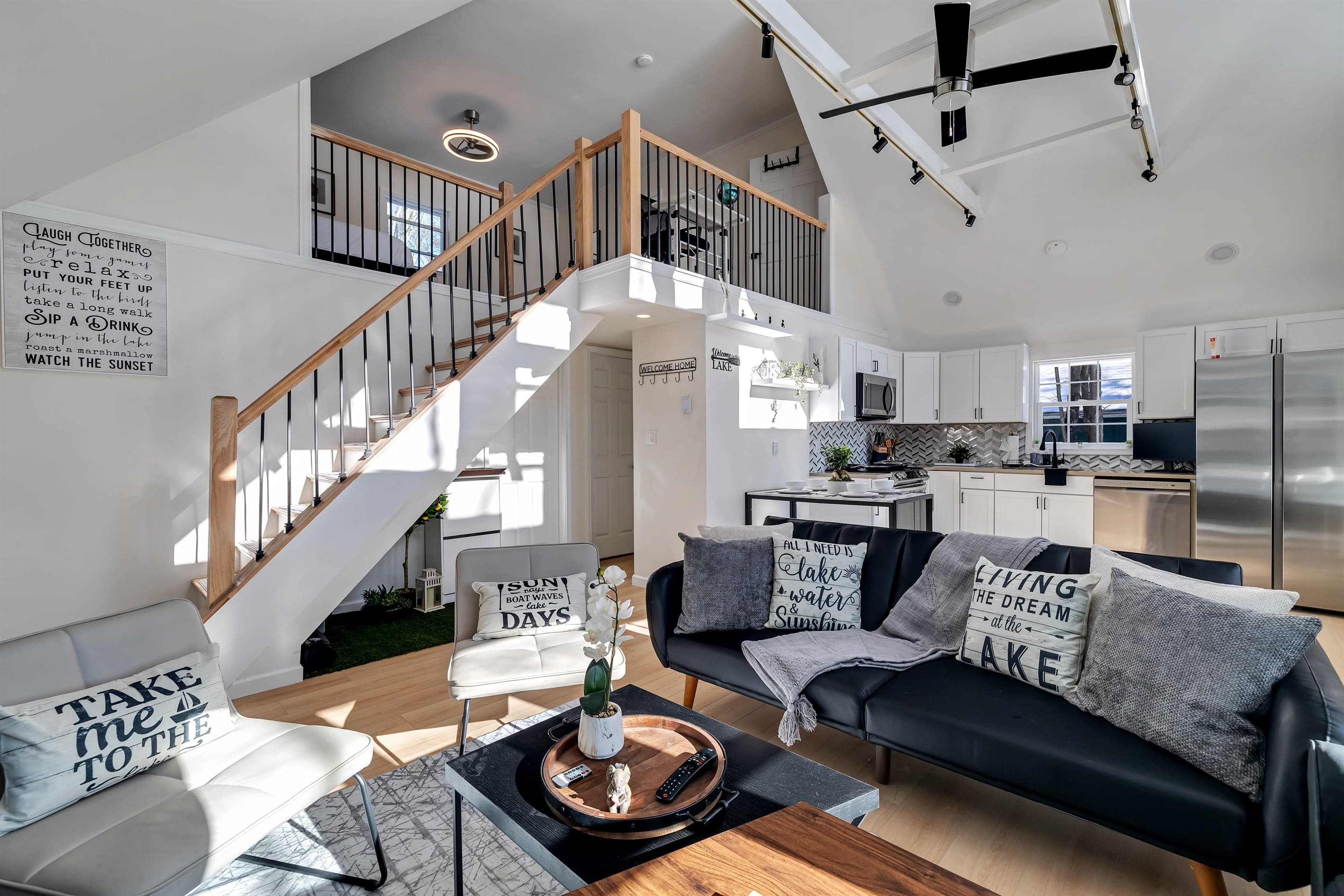 View of living room, with kitchen and loft