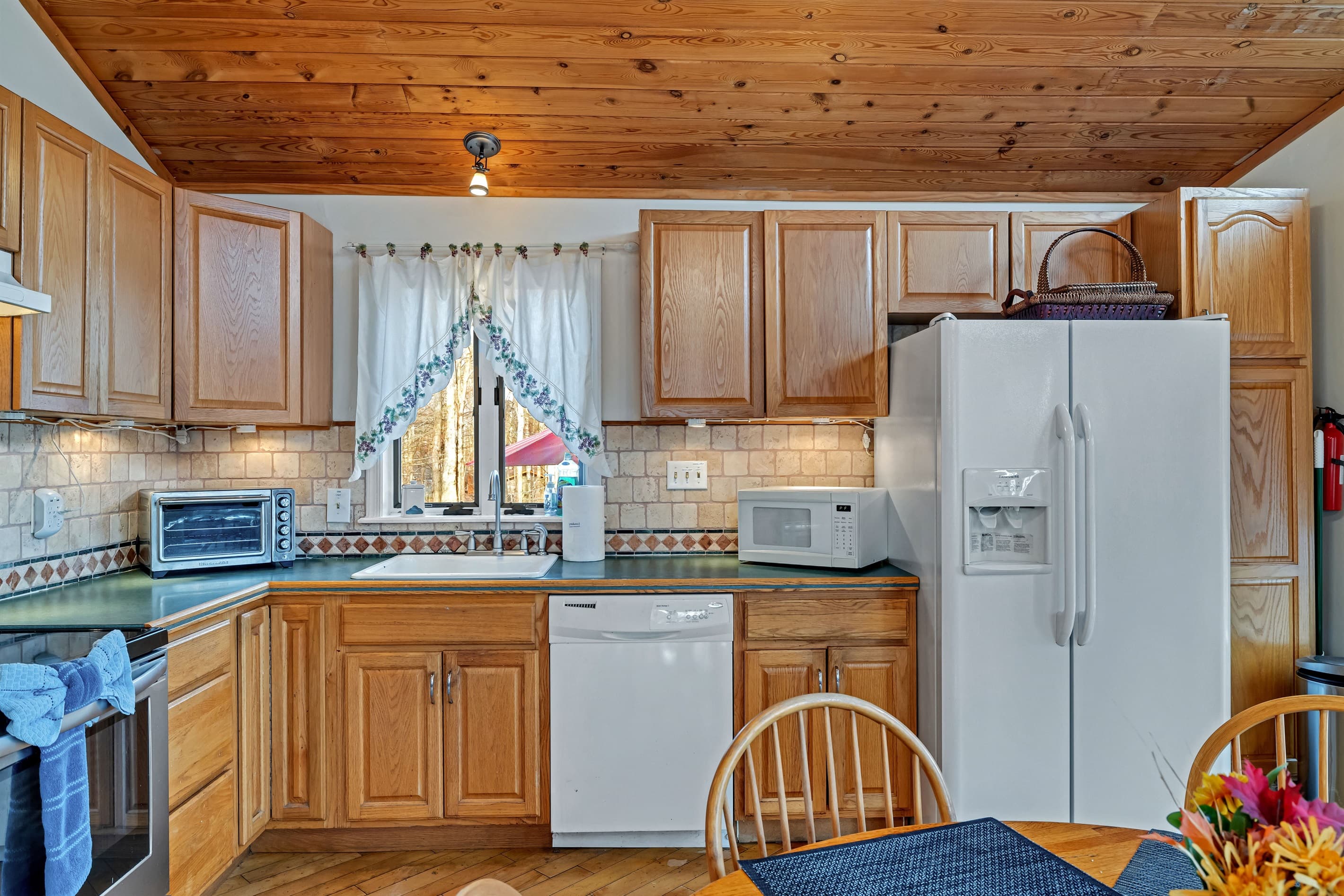 Fully stocked kitchen with large fridge, dishwasher, microwave, oven toaster, coffeemaker