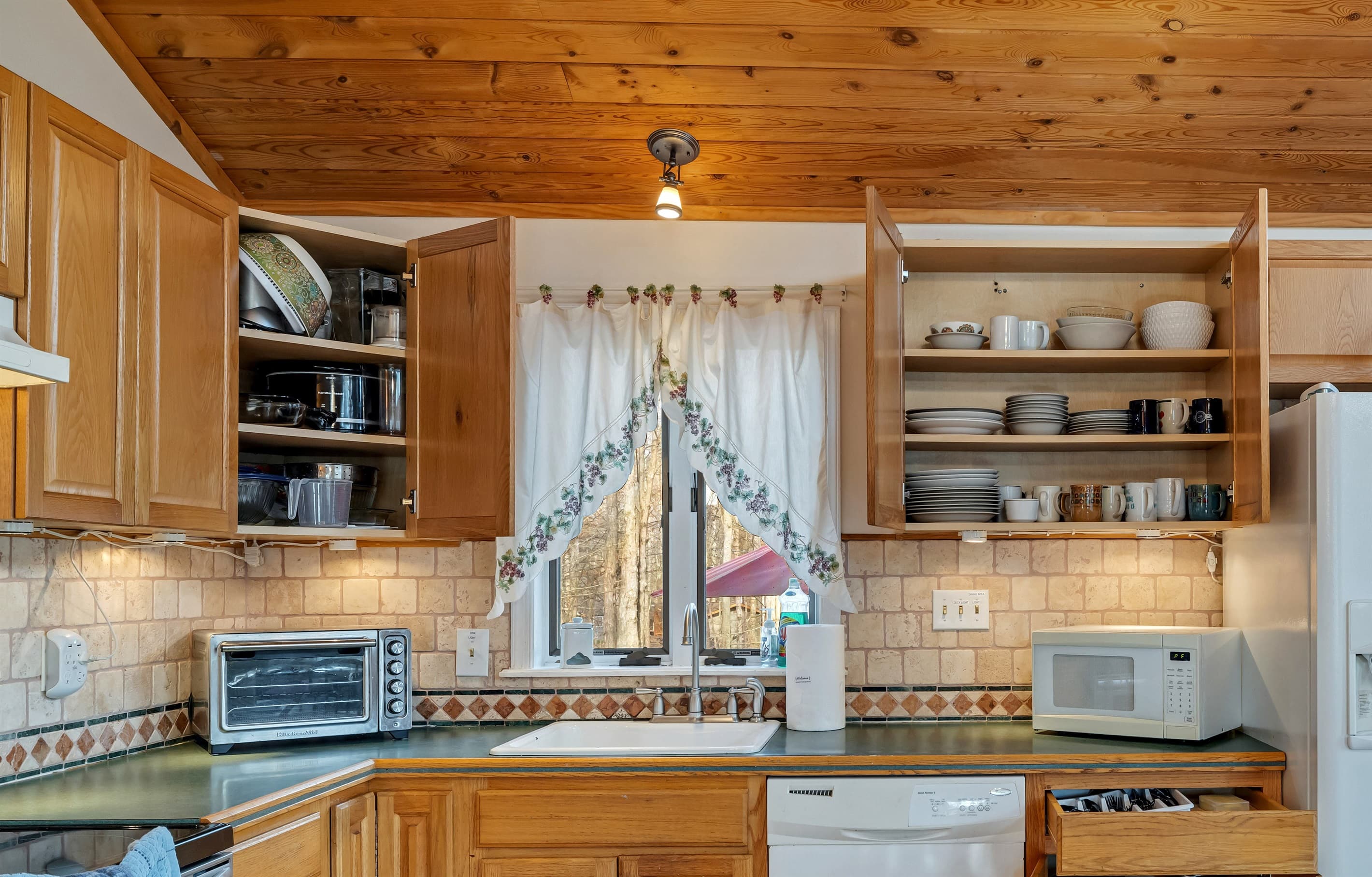 Fully stocked kitchen with large fridge, dishwasher, microwave, oven toaster, coffeemaker