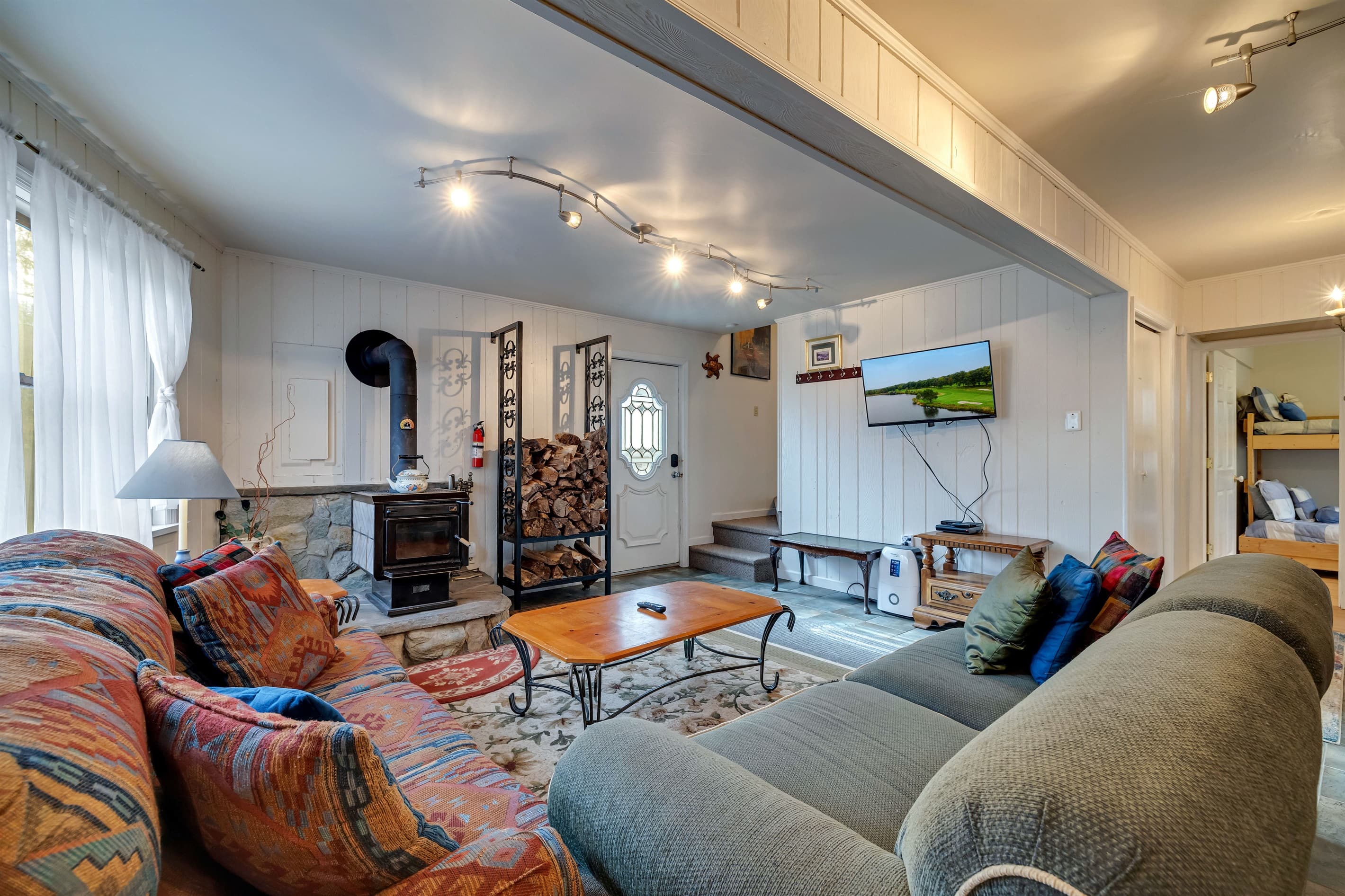 Lower-level family room with wood burning fireplace and TV