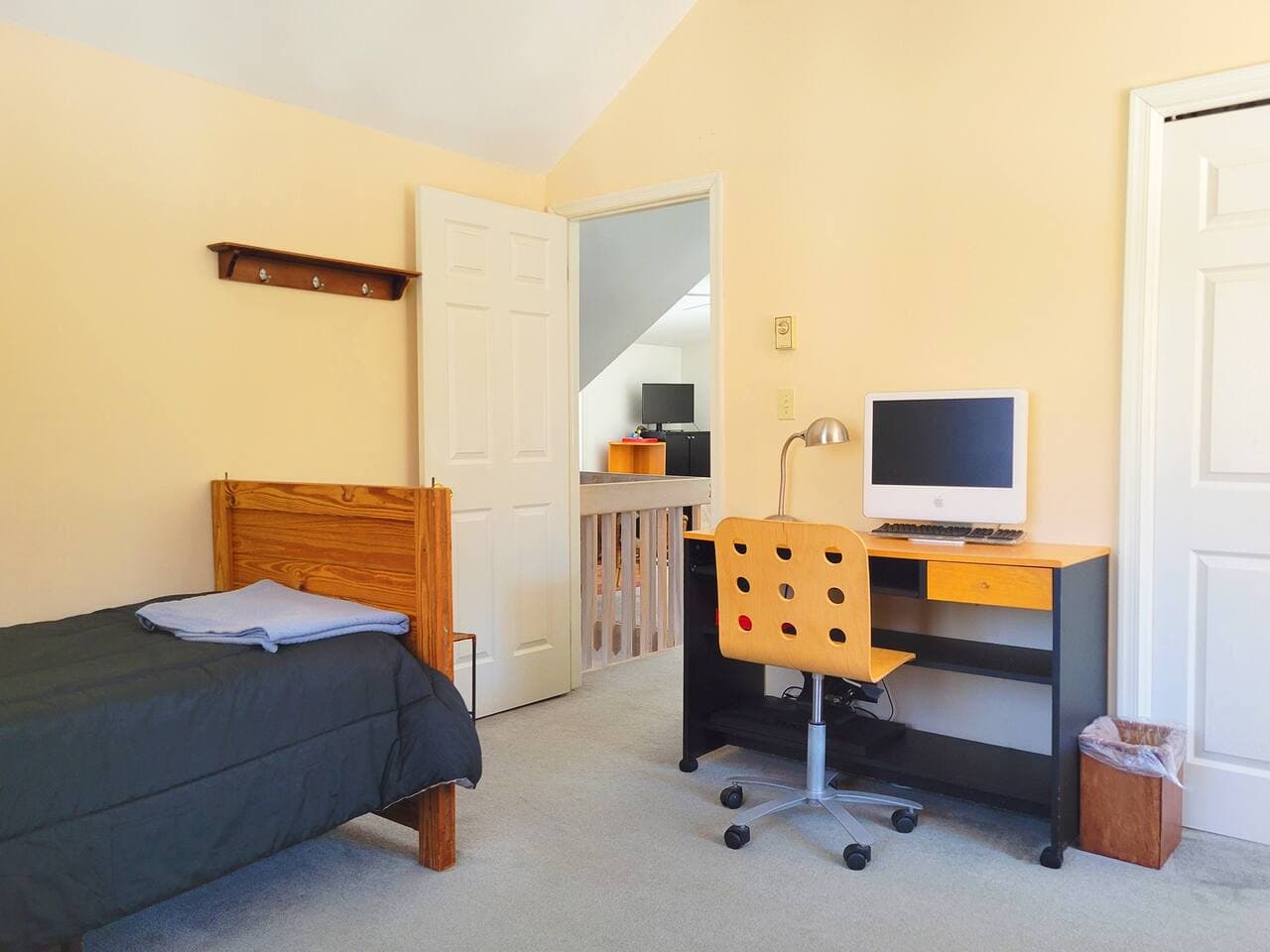 This bedroom has a twin size single bed, twin size bunk bed, closet and a workstation with chair