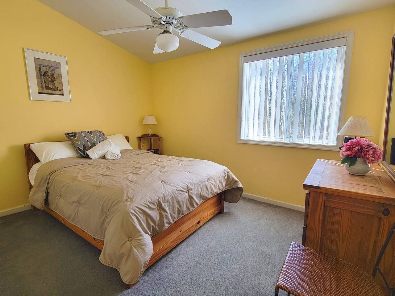 This bedroom has a full size bed and a dresser with mirror