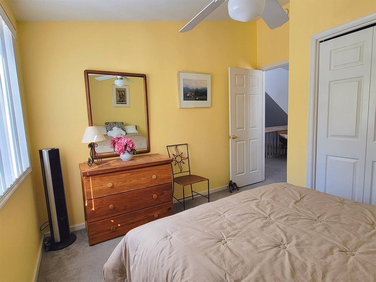 This bedroom has a full size bed and a dresser with mirror