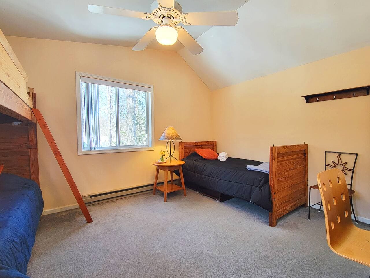 This bedroom has a twin size single bed, twin size bunk bed, closet and a workstation with chair