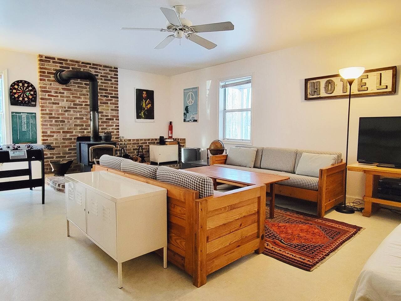 Lower level living room with TV, wood burning firestove and foosball table
