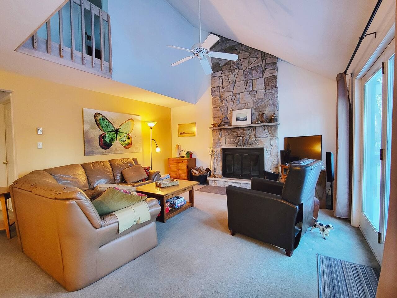 Sectional couch and TV next to fireplace in main living room