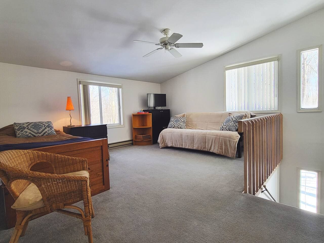 Upper level living room has two sleeping beds and tv