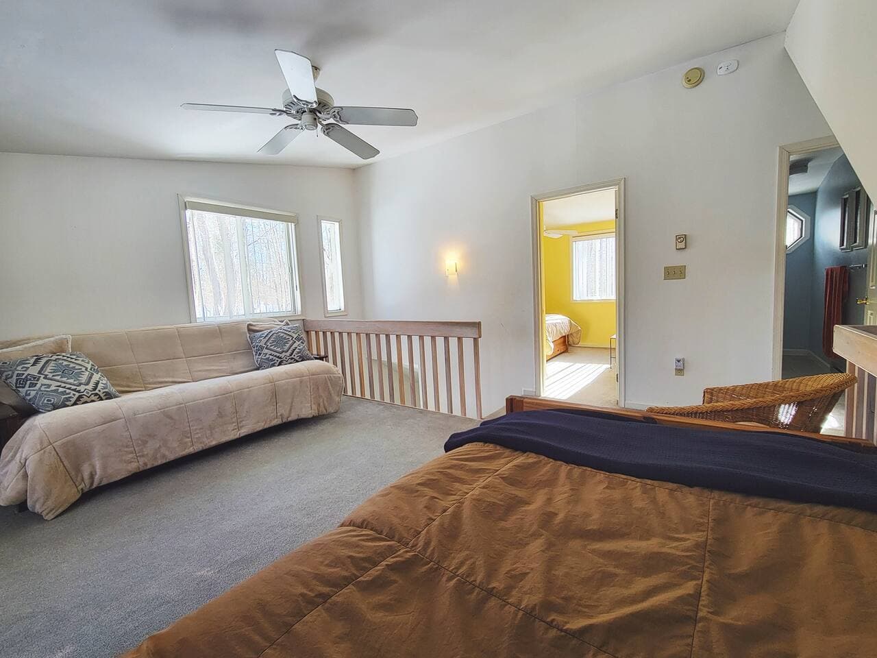 Upper level living room has two sleeping beds and tv