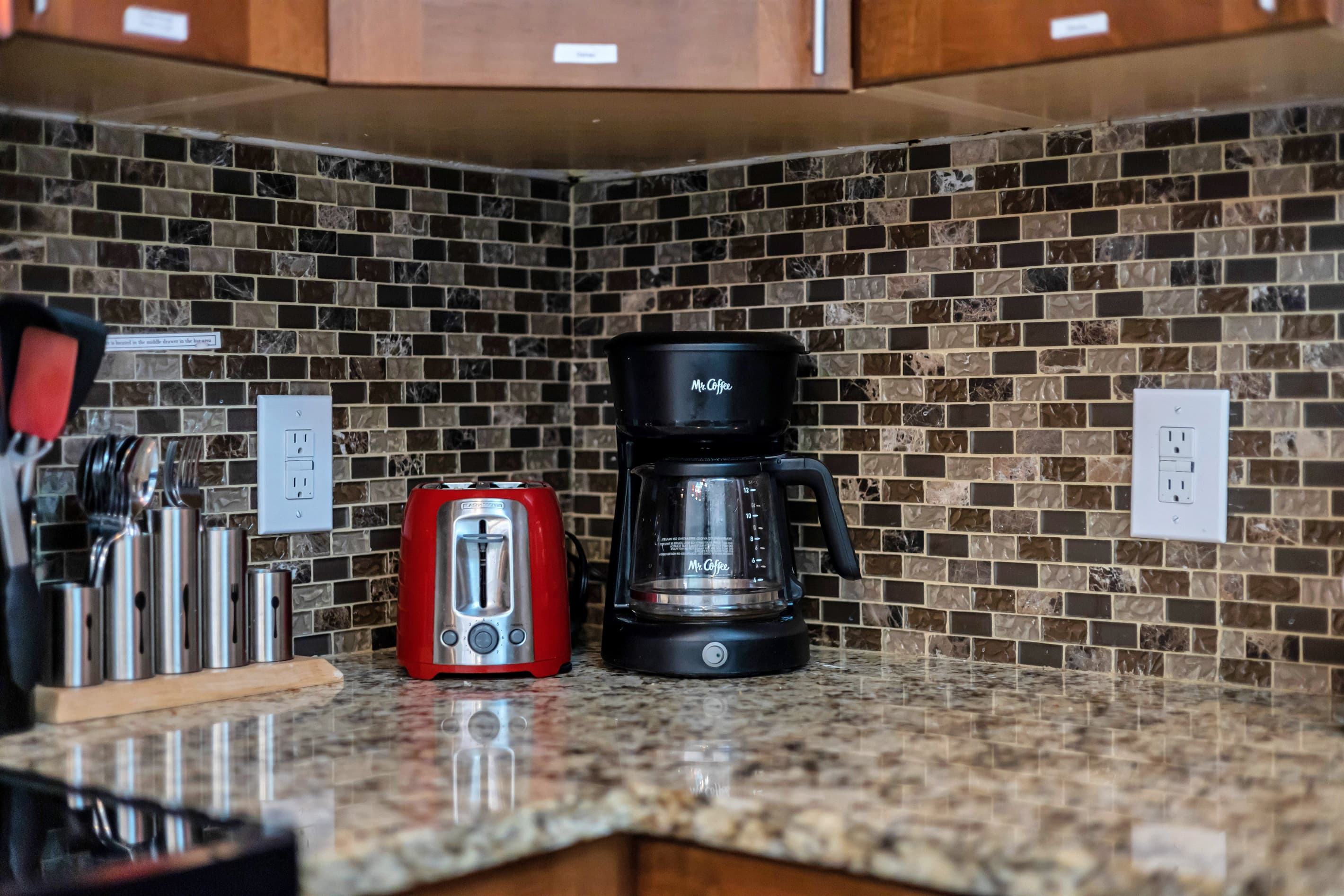 Kitchen equipped with a coffeemaker and toaster among other small appliances.