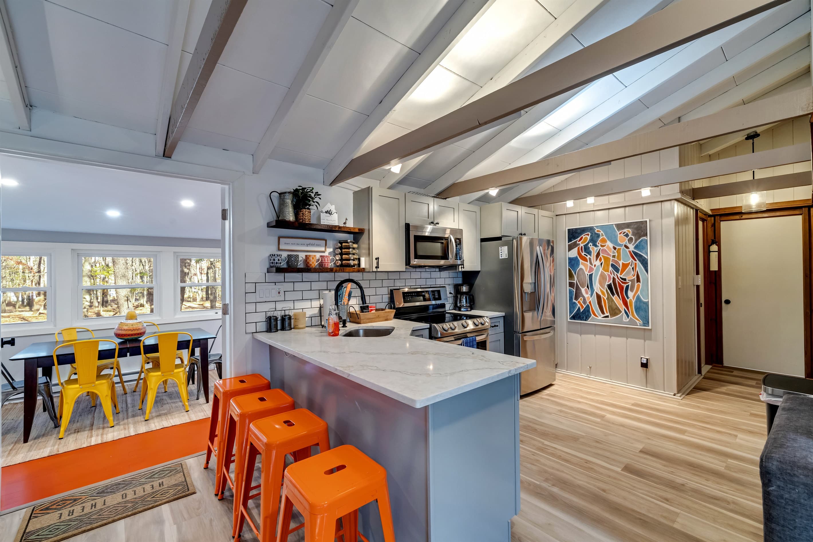 Modern kitchen with sleek quartz countertops, stainless steel appliances, and a breakfast counter, offering a stylish and functional space for cooking and dining | Serhii Vacation Rentals