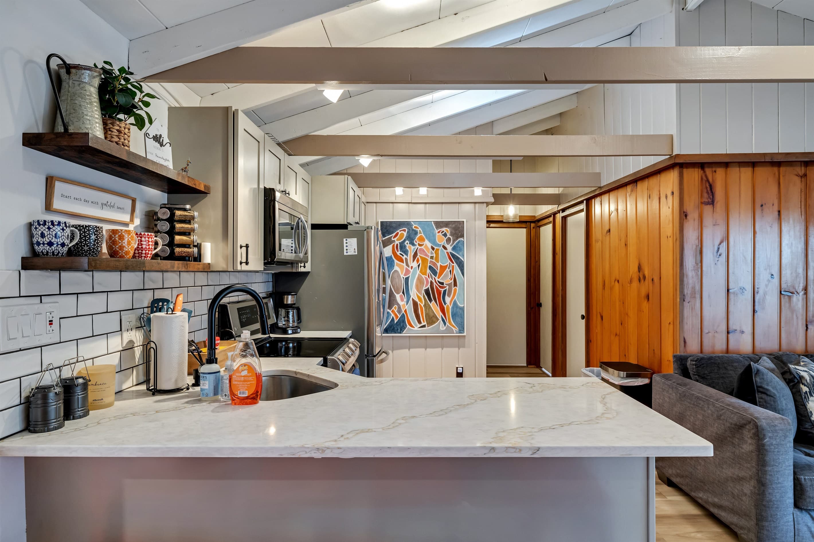 Modern kitchen with sleek quartz countertops, stainless steel appliances, and a breakfast counter, offering a stylish and functional space for cooking and dining | Serhii Vacation Rentals