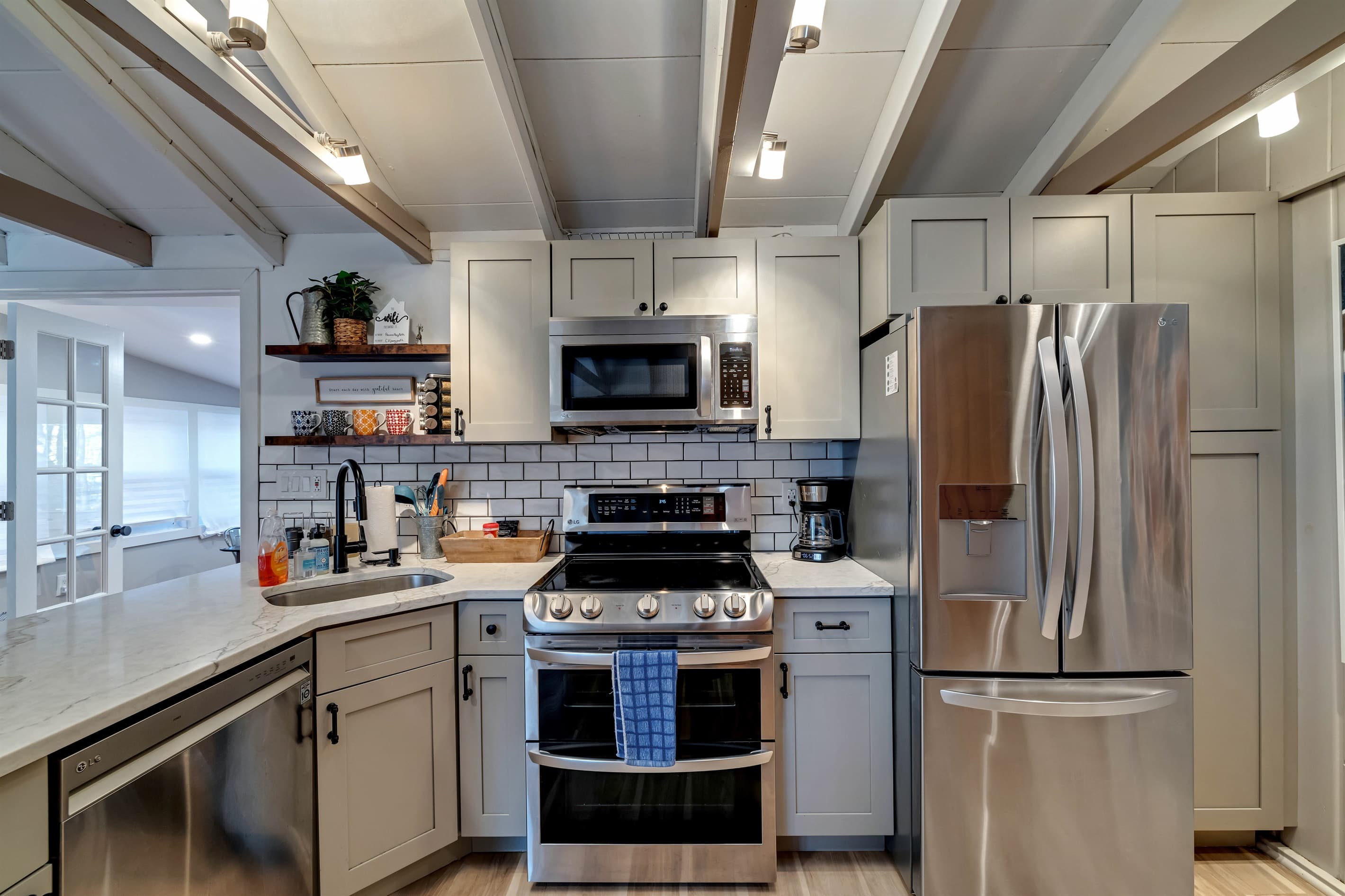 Modern kitchen with sleek quartz countertops, stainless steel appliances, and a breakfast counter, offering a stylish and functional space for cooking and dining | Serhii Vacation Rentals