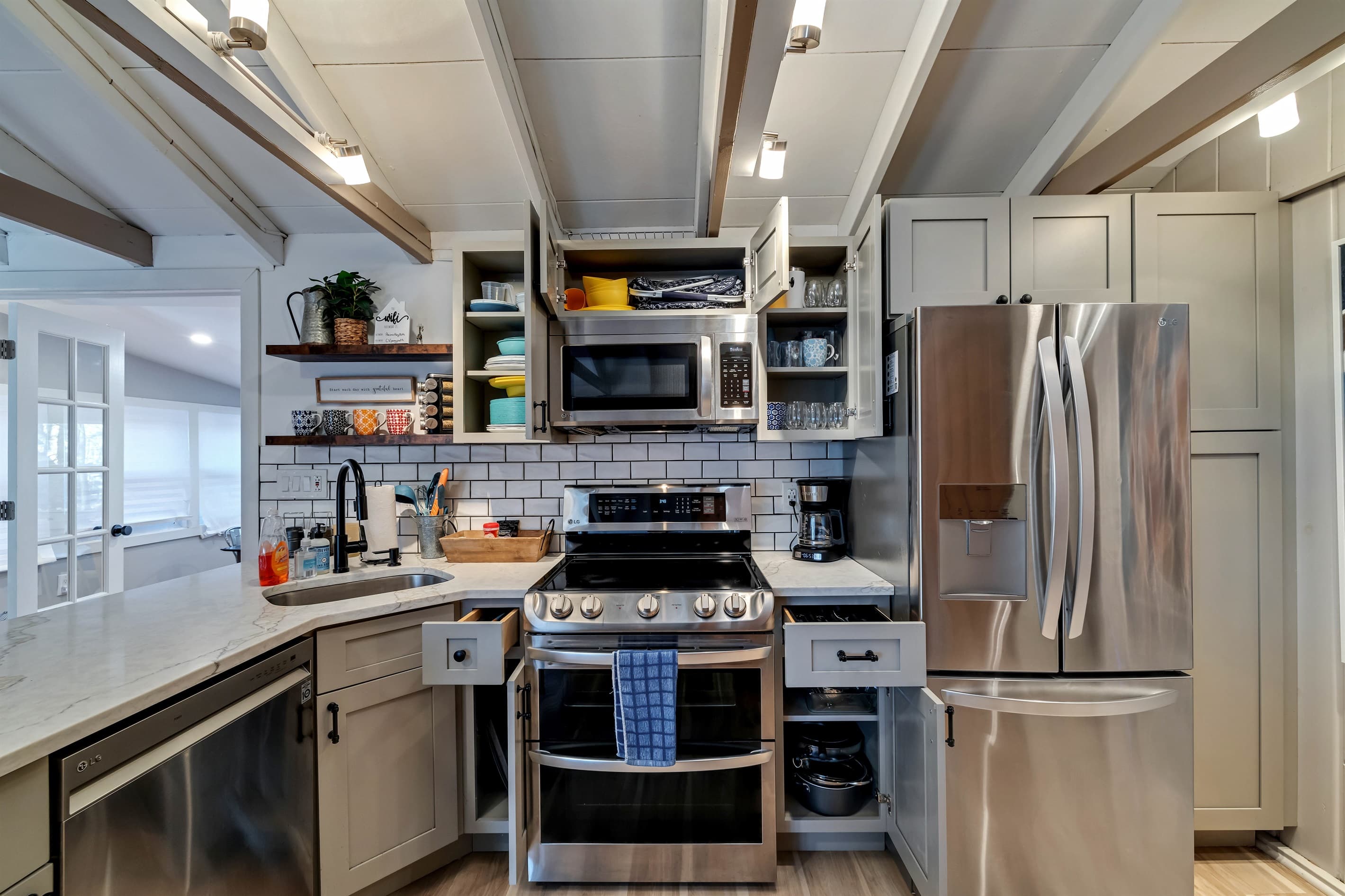 Modern kitchen with sleek quartz countertops, stainless steel appliances, and a breakfast counter, offering a stylish and functional space for cooking and dining | Serhii Vacation Rentals