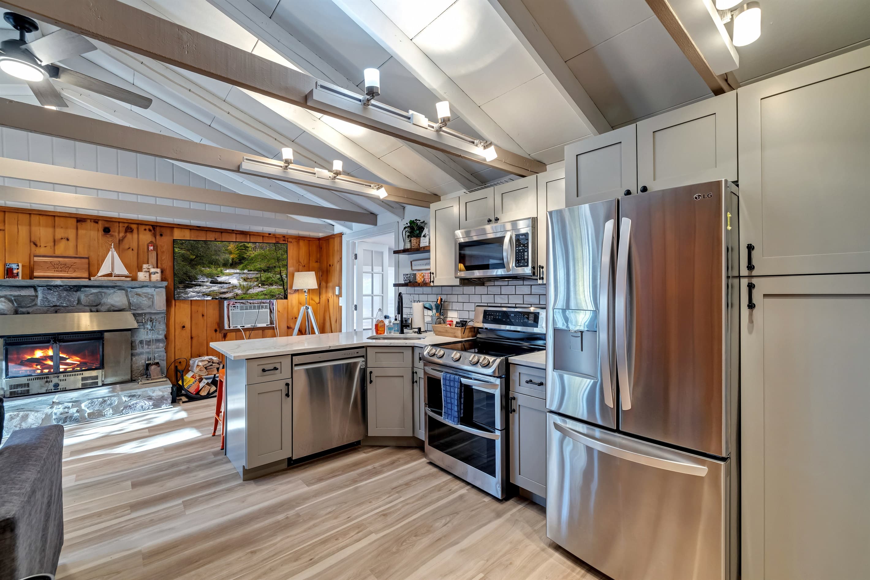 Modern kitchen with sleek quartz countertops, stainless steel appliances, and a breakfast counter, offering a stylish and functional space for cooking and dining | Serhii Vacation Rentals