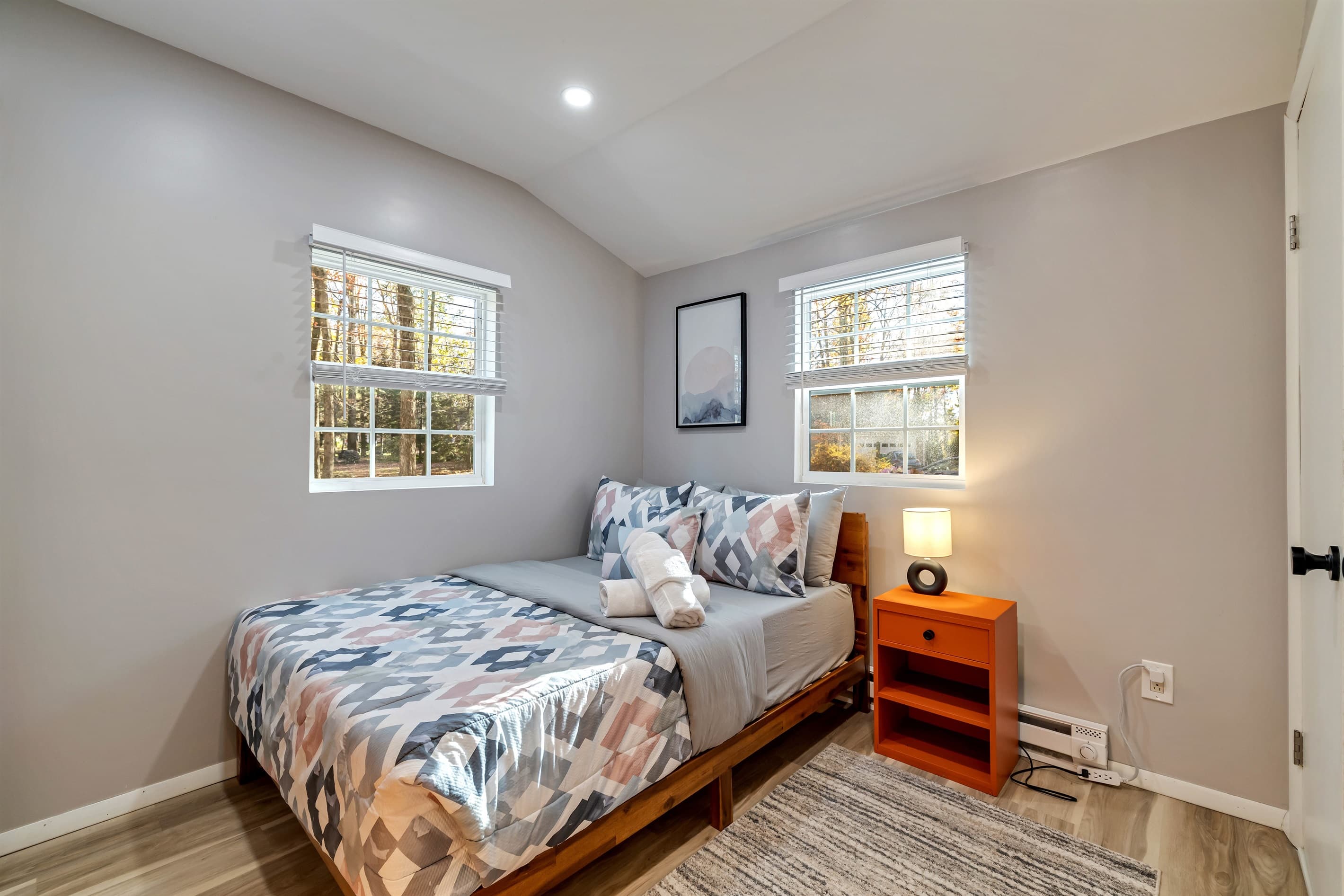 Bedroom with an adjacent bathroom featuring a toilet and sink, offering added convenience and privacy. A comfortable setup for a relaxing stay