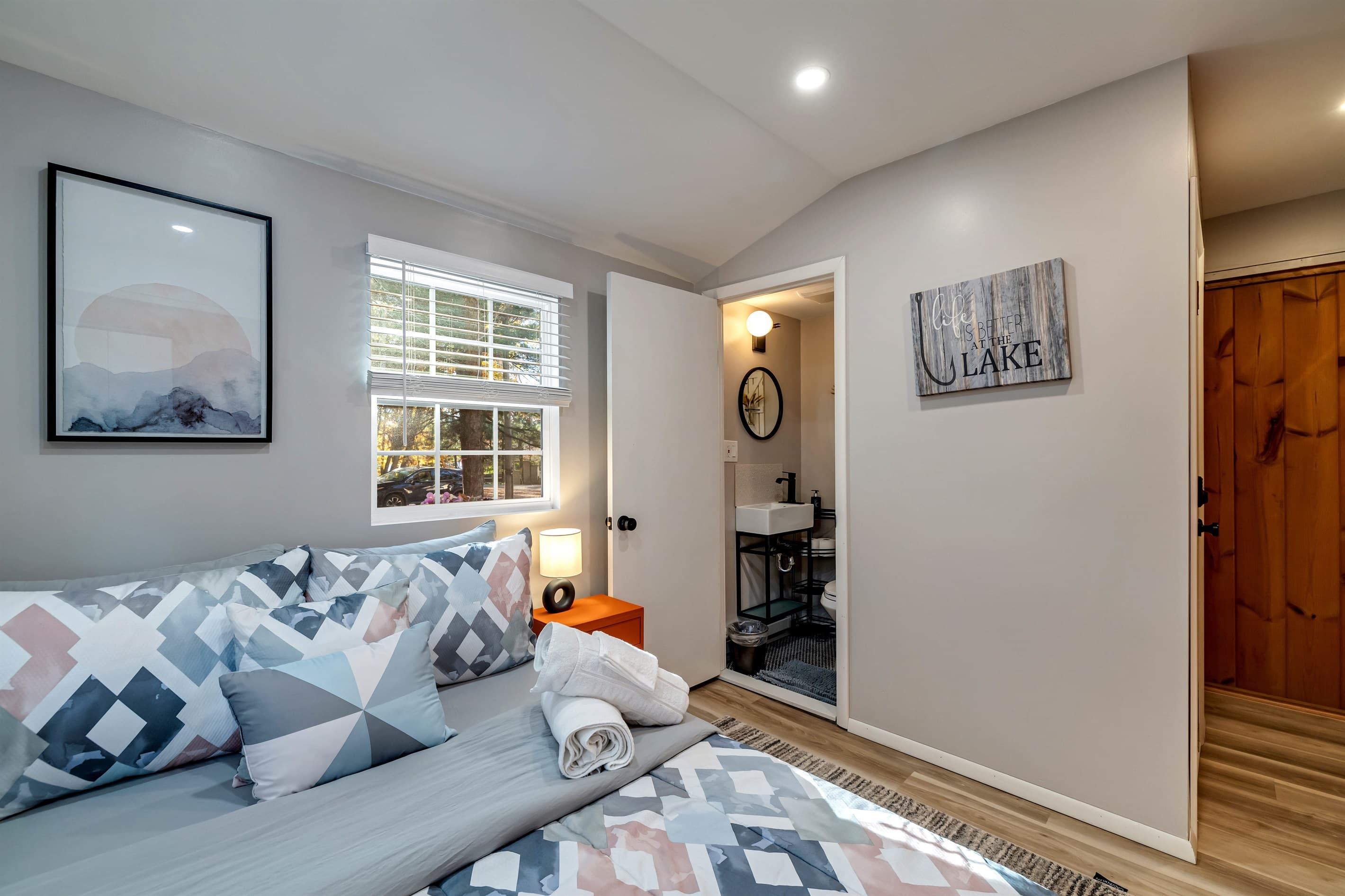 Bedroom with an adjacent bathroom featuring a toilet and sink, offering added convenience and privacy. A comfortable setup for a relaxing stay