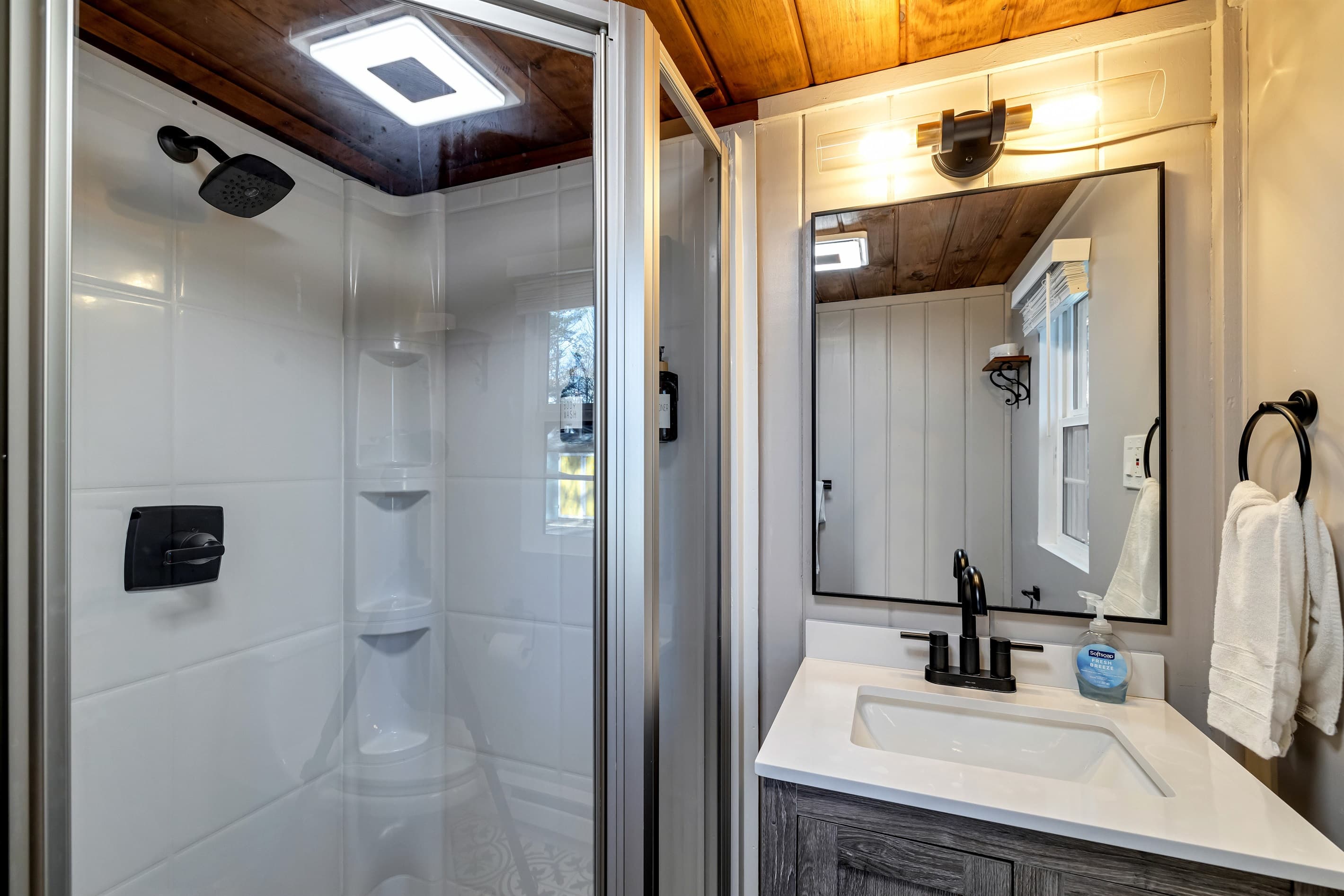Bathroom with a toilet, sink, and corner shower, offering a practical space for your daily routine. Convenient and comfortable for your stay!