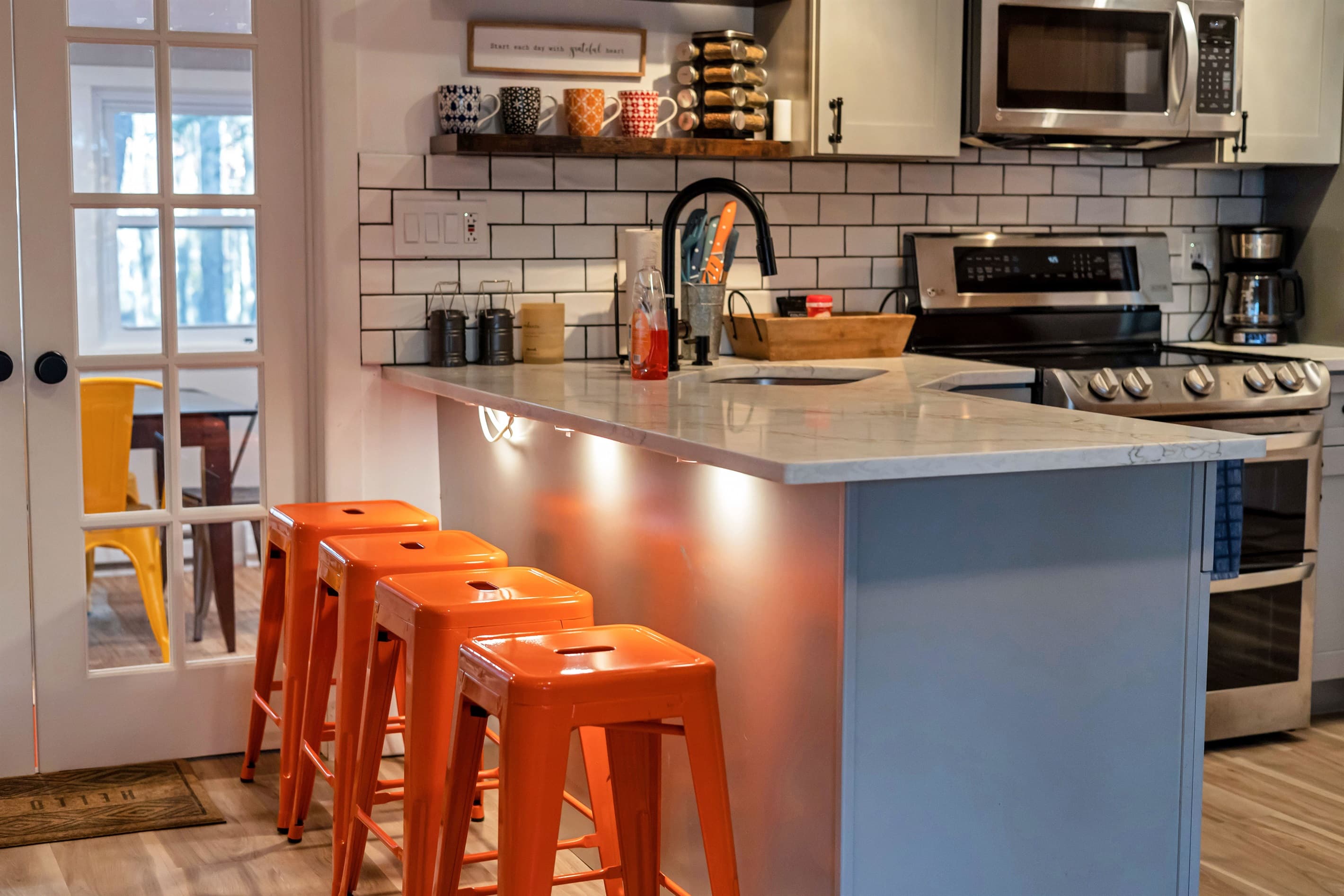 Modern kitchen with sleek quartz countertops, stainless steel appliances, and a breakfast counter, offering a stylish and functional space for cooking and dining | Serhii Vacation Rentals