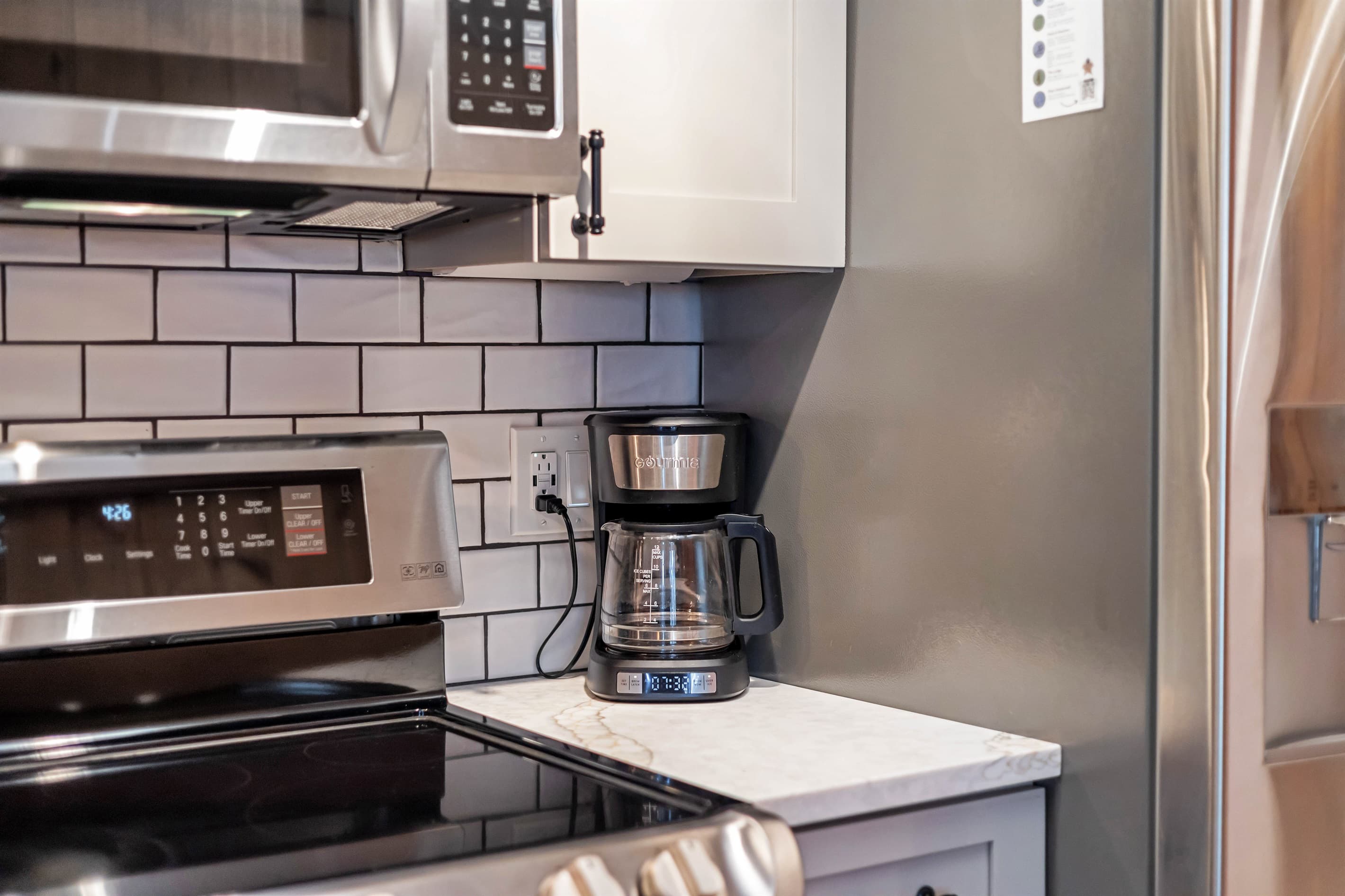 Modern kitchen with sleek quartz countertops, stainless steel appliances, and a breakfast counter, offering a stylish and functional space for cooking and dining | Serhii Vacation Rentals