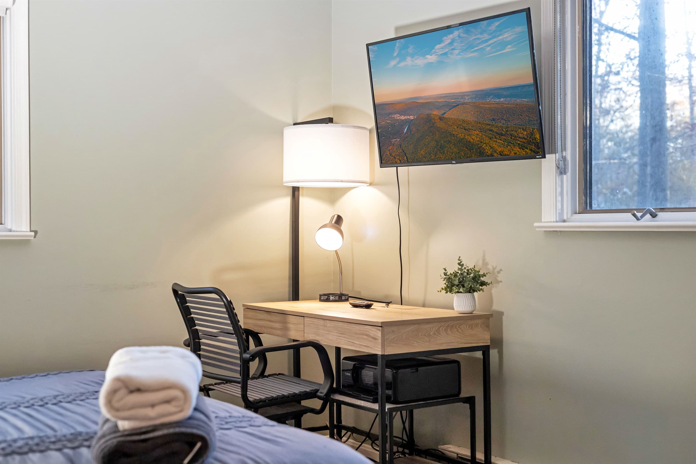 Cozy small workspace located in one of the bedrooms, featuring a simple desk and chair, ideal for remote work or quiet study