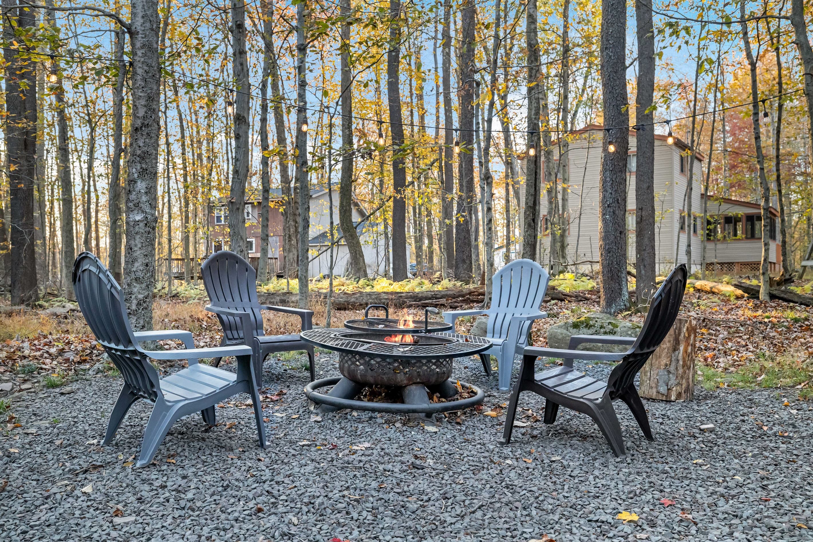 Charming backyard with string lights creating a warm ambiance, a firepit with seating for cozy evenings under the stars—perfect for gathering with friends and family