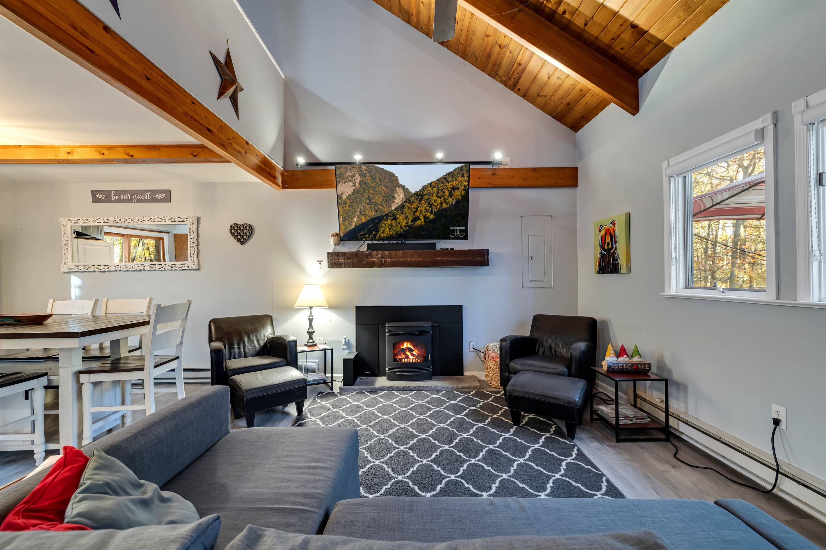 Living room featuring a large TV, pellet fireplace, sectional couch, and a couple of chairs, offering a cozy and comfortable space to relax and unwind | Serhii Vacation Rentals