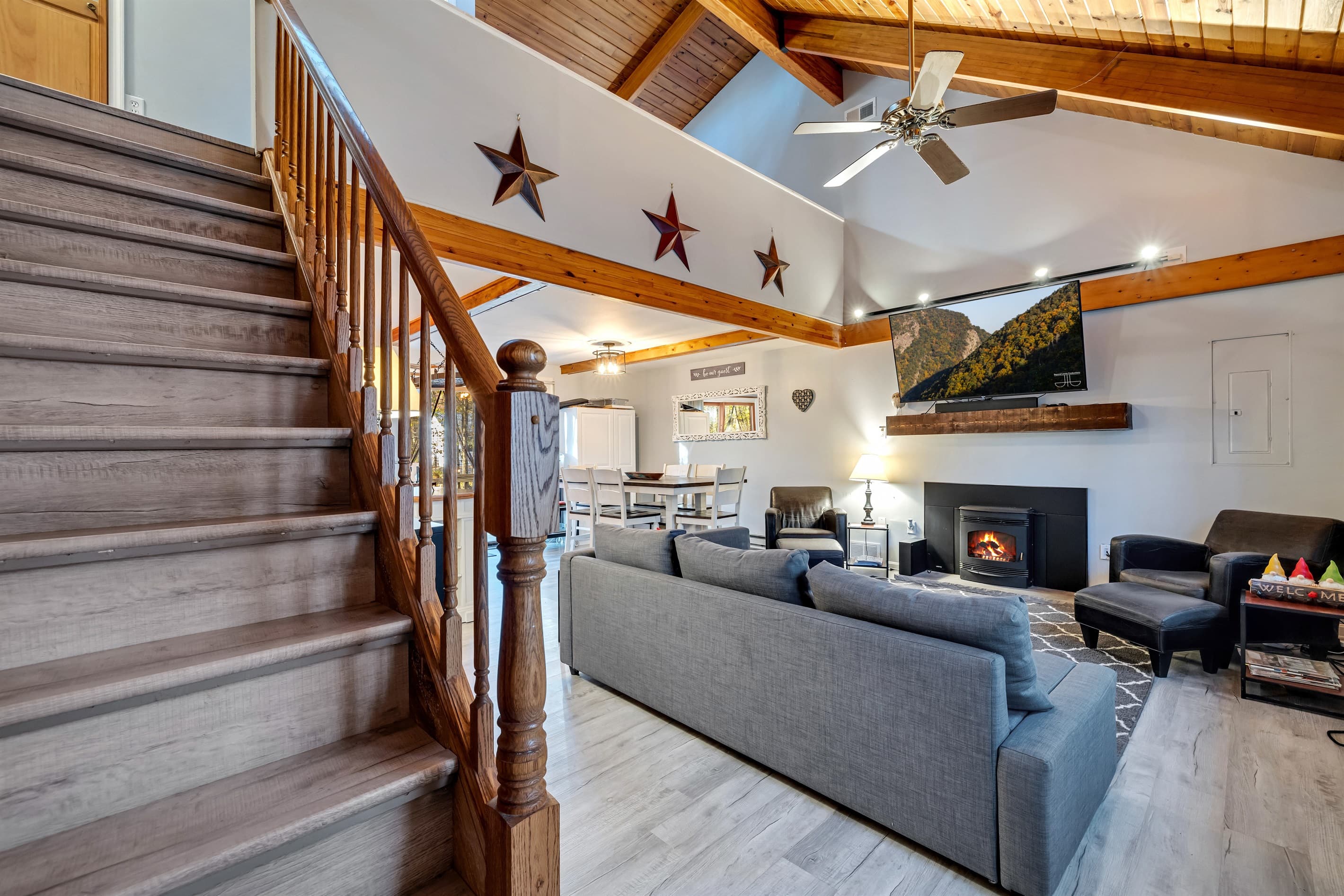Living room featuring a large TV, pellet fireplace, sectional couch, and a couple of chairs, offering a cozy and comfortable space to relax and unwind | Serhii Vacation Rentals