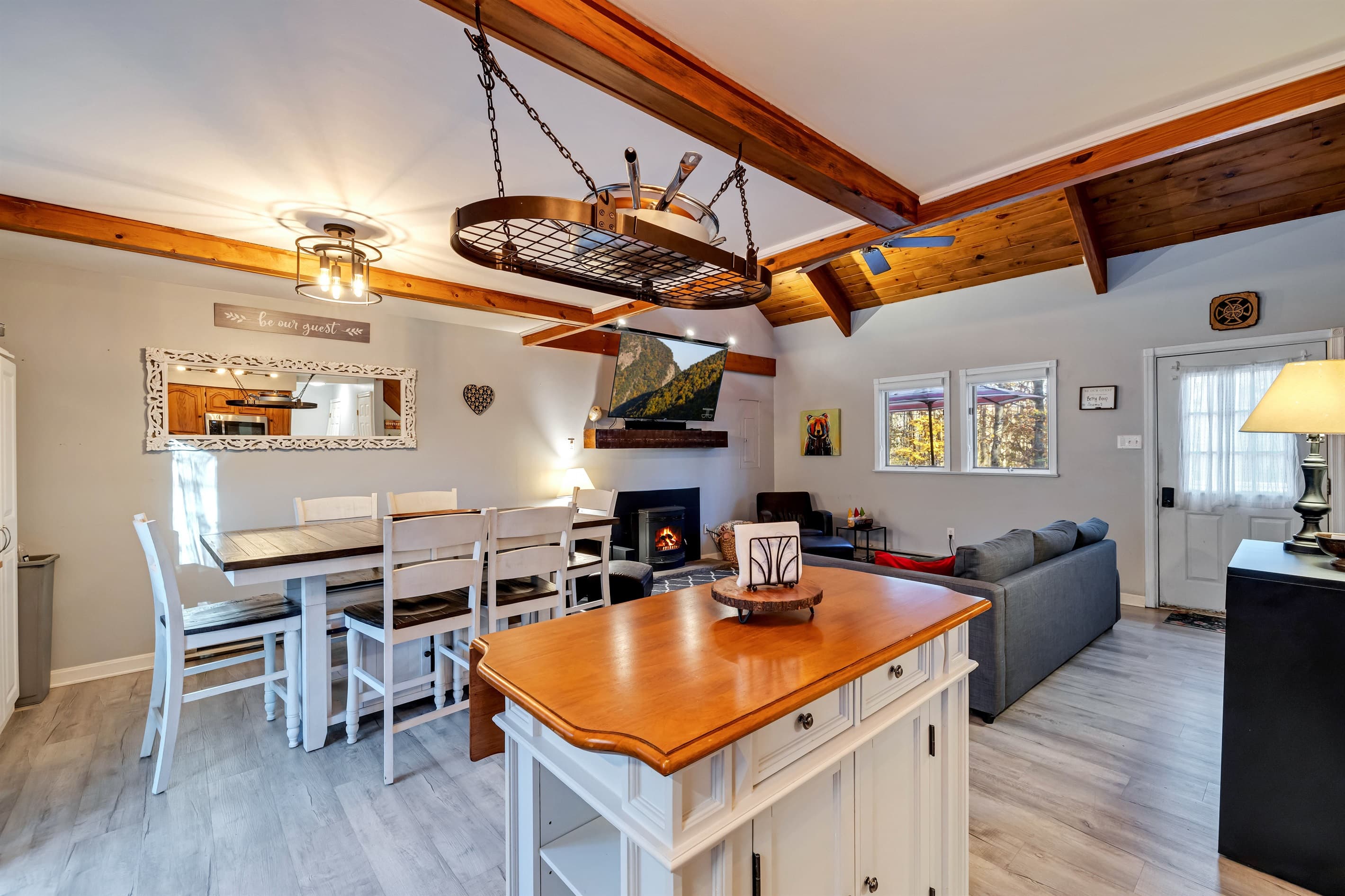 View of the kitchen island with the dining area and living room in the background, creating a spacious, open layout perfect for cooking, dining, and relaxing.
