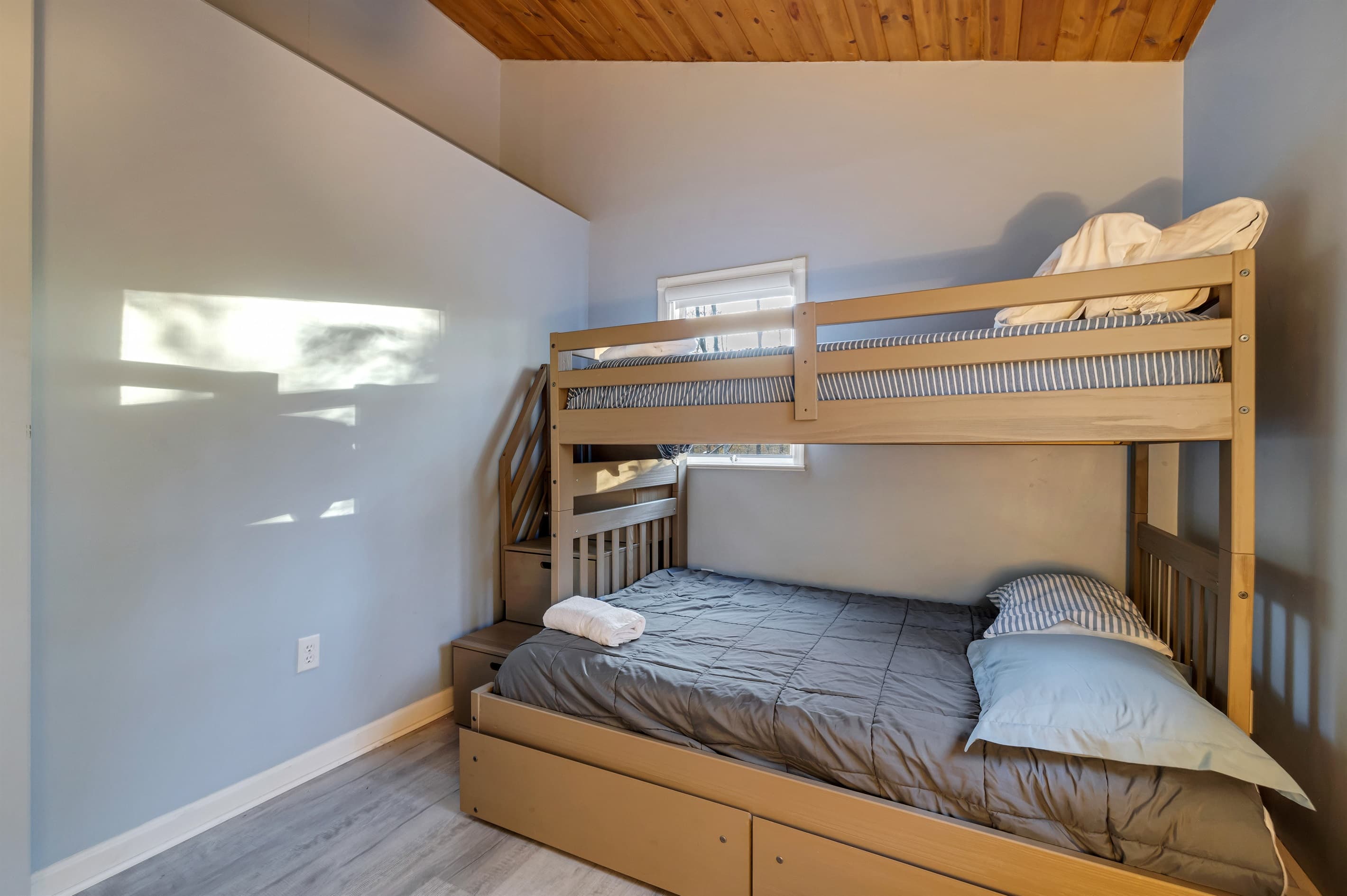 Bedroom with a twin-over-full bunk bed, perfect for kids or adults seeking a fun and cozy sleeping arrangement after a day of adventure.
