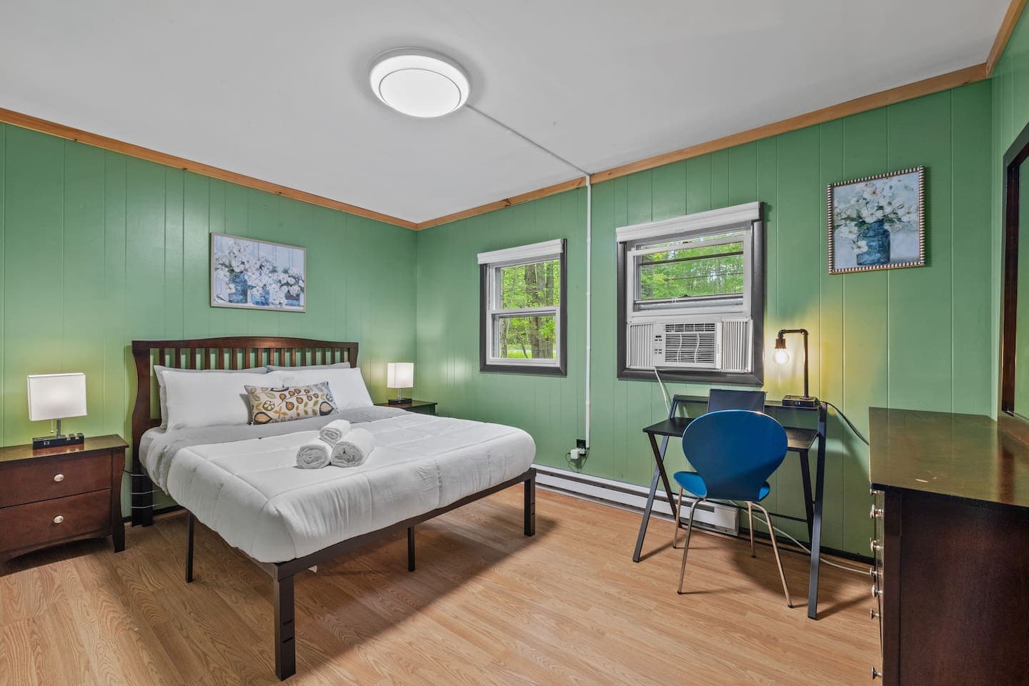 Rest easy in this cozy bedroom featuring a queen bed and mirrored dresser.