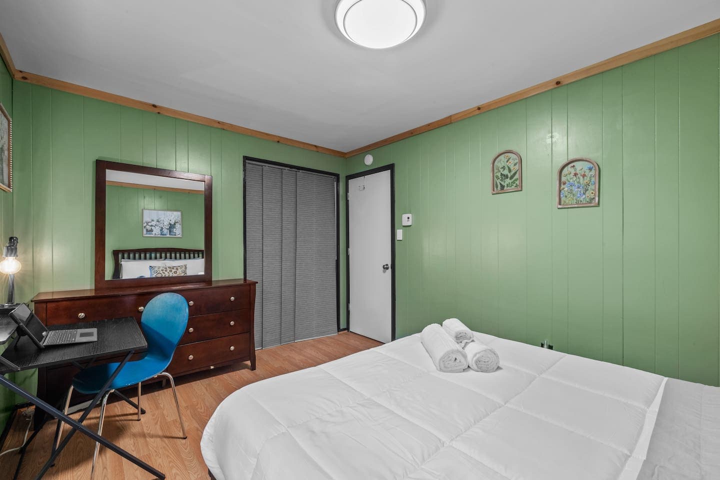 Rest easy in this cozy bedroom featuring a queen bed and mirrored dresser.