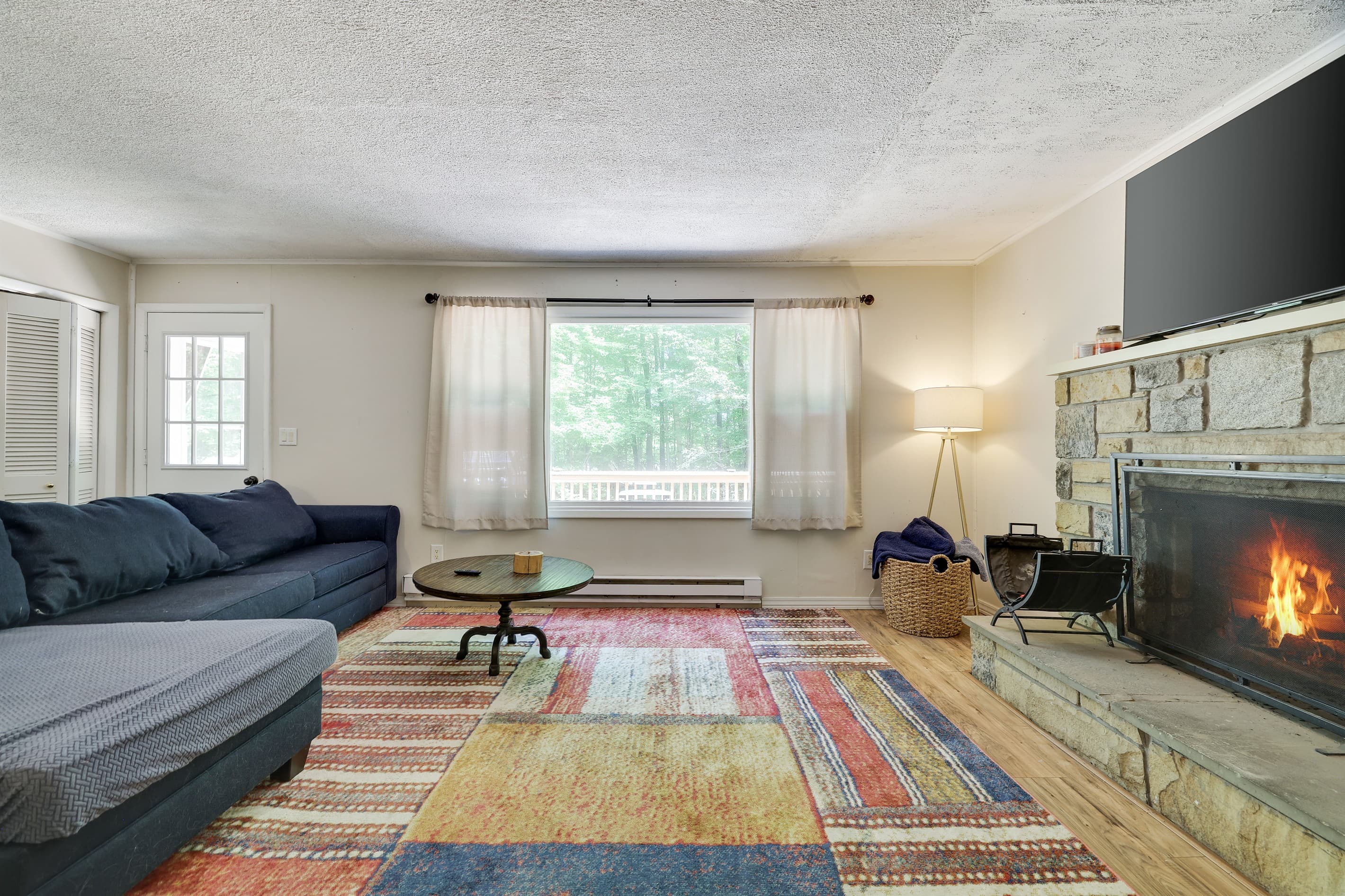 Upper level living room with TV and wood burning fireplace