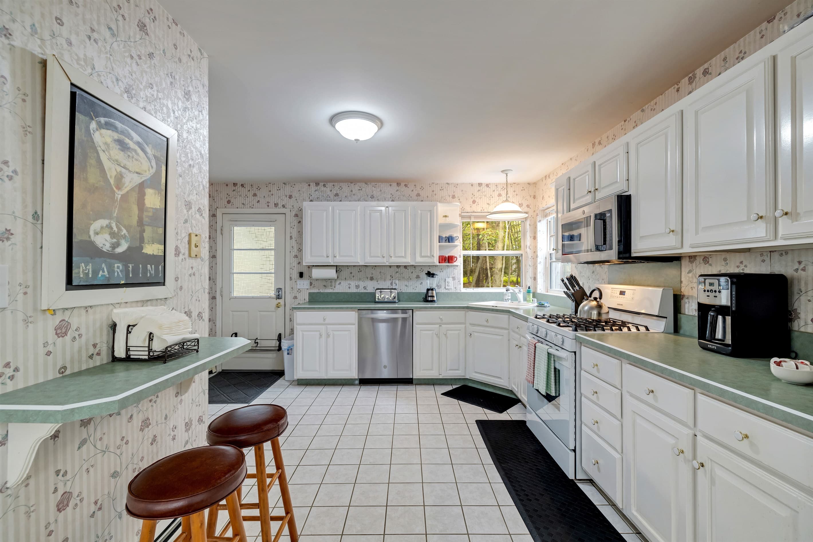 Fully stocked kitchen with lots of space: dishwasher, fridge, blender, microwave, toaster