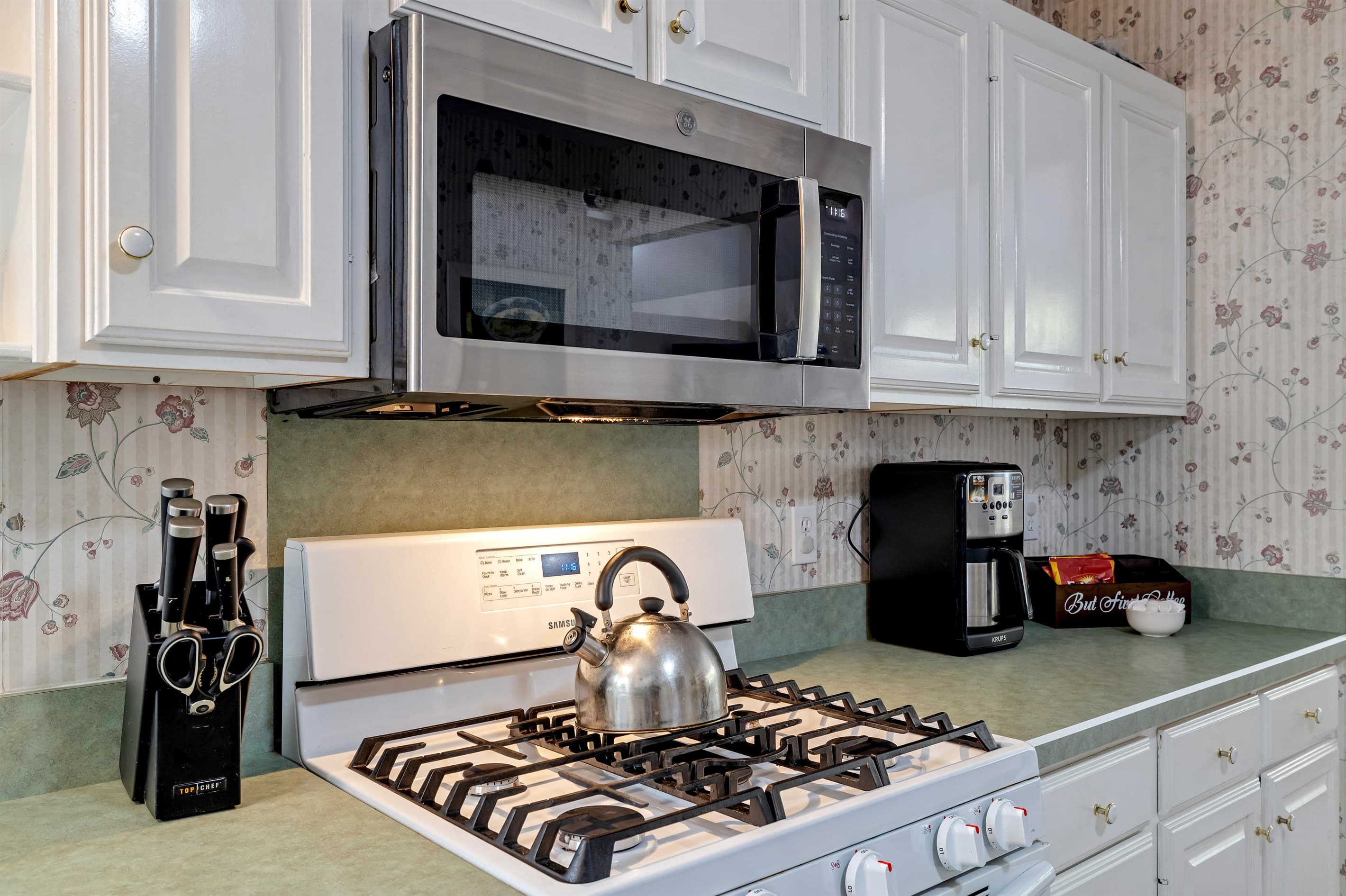 Fully stocked kitchen with lots of space: dishwasher, fridge, blender, microwave, toaster